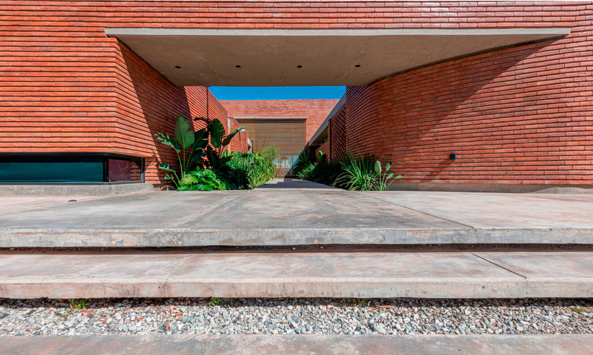 A considered entry sequence where water and garden elements guide movement, turning arrival into a calm, intentional experience within this brick family house in Córdoba.