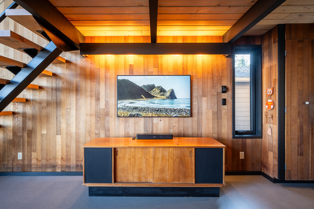 La eliminación de la chimenea de ladrillo original permitió elevar la casa. En su lugar hay una chimenea flotante de estilo medieval apoyada contra una pared de azulejos. La gran sala, donde se encuentra la sala de estar, se siente más luminosa y relajada, enfatizando la apertura y la conexión con el exterior.