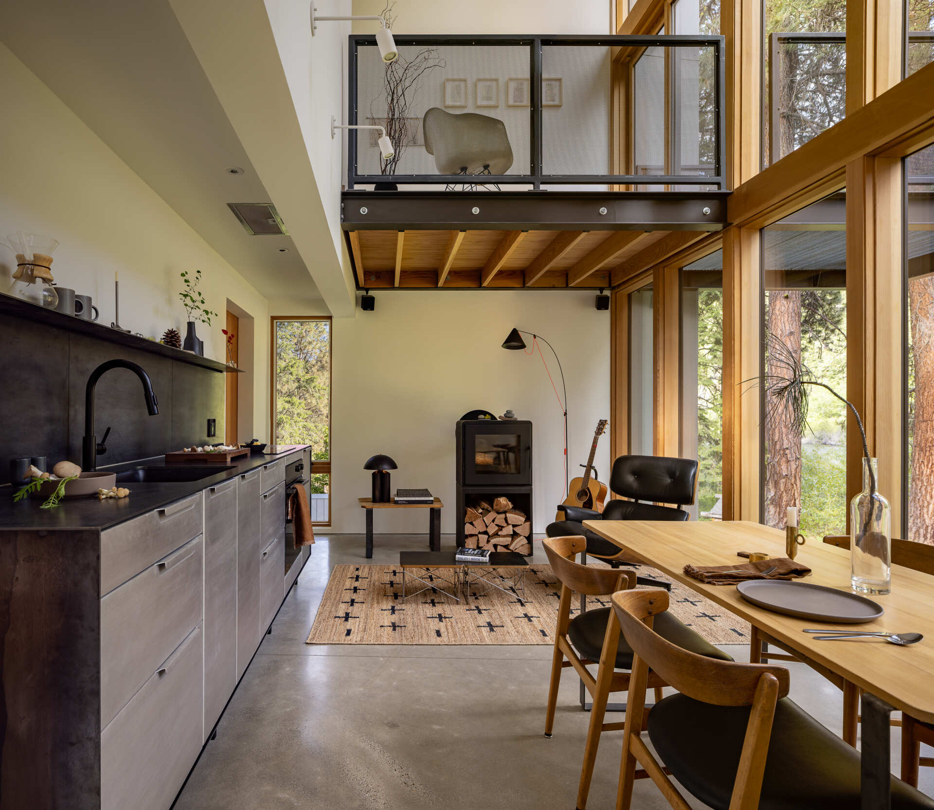 The middle level is organized as a single open room that brings together the living, dining, and kitchen areas, along with a full bathroom. This floor functions as the social heart of the cabin, where daily life unfolds around shared space rather than separate rooms.