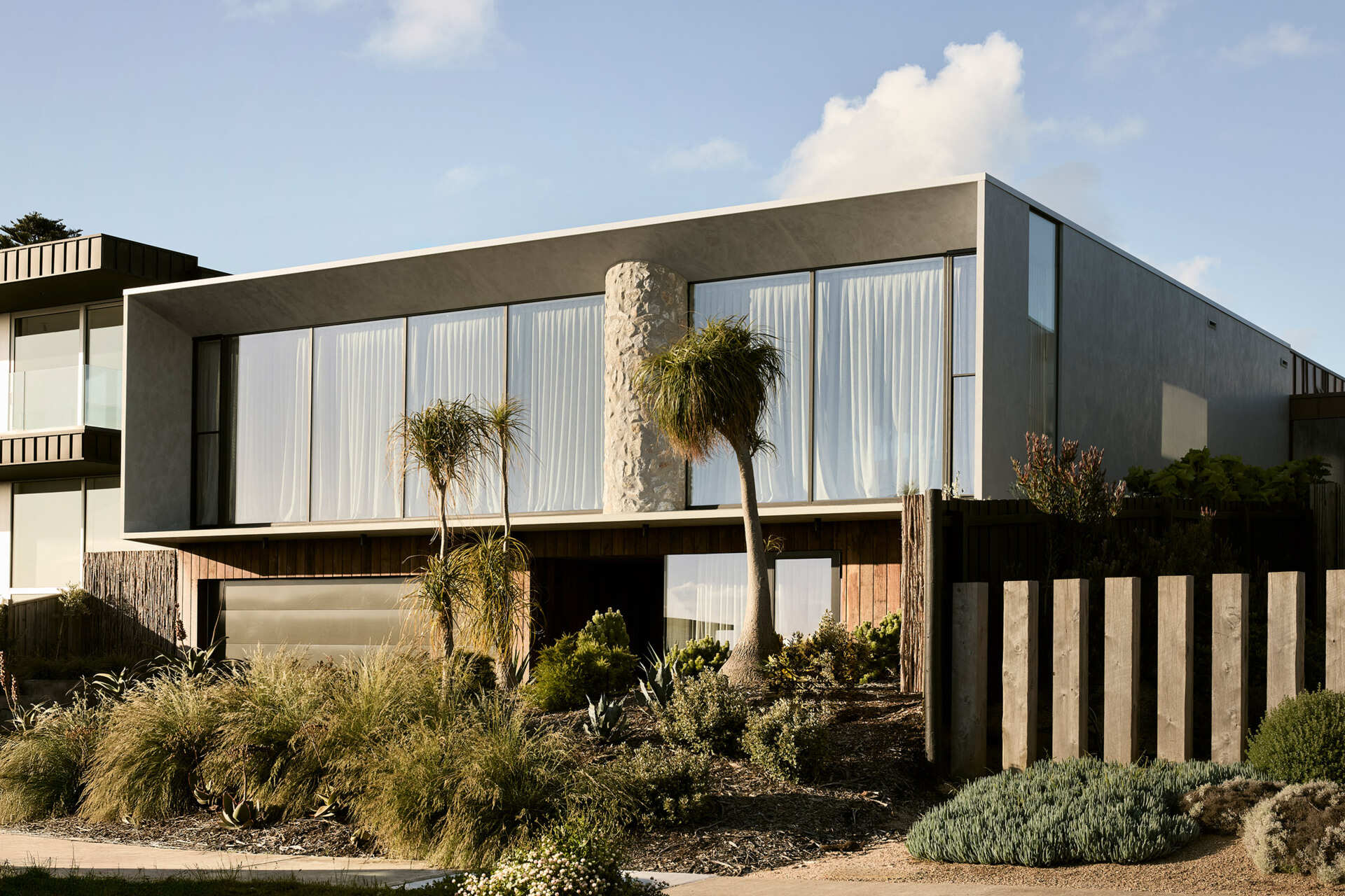 Recycled timber, concrete, limestone, and copper define a coastal home built to weather and remain refined over time.