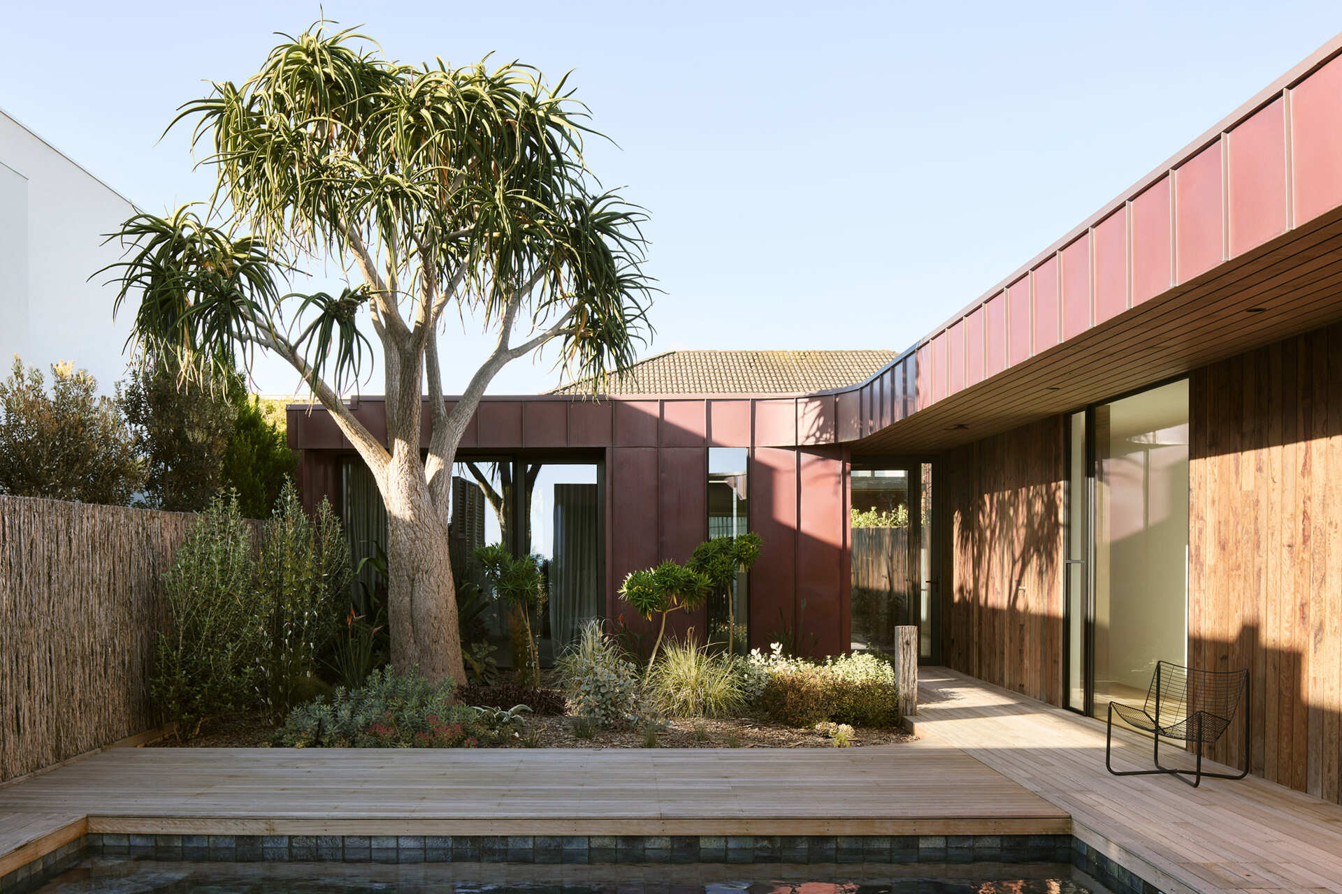 A sheltered pool and courtyard sit at the heart of this Ocean Grove home, where a semi courtyard layout draws in northern light while protecting outdoor spaces from coastal winds. Natural materials, planted gardens, and strong visual links to the interiors create a calm, private setting designed to be used year round.