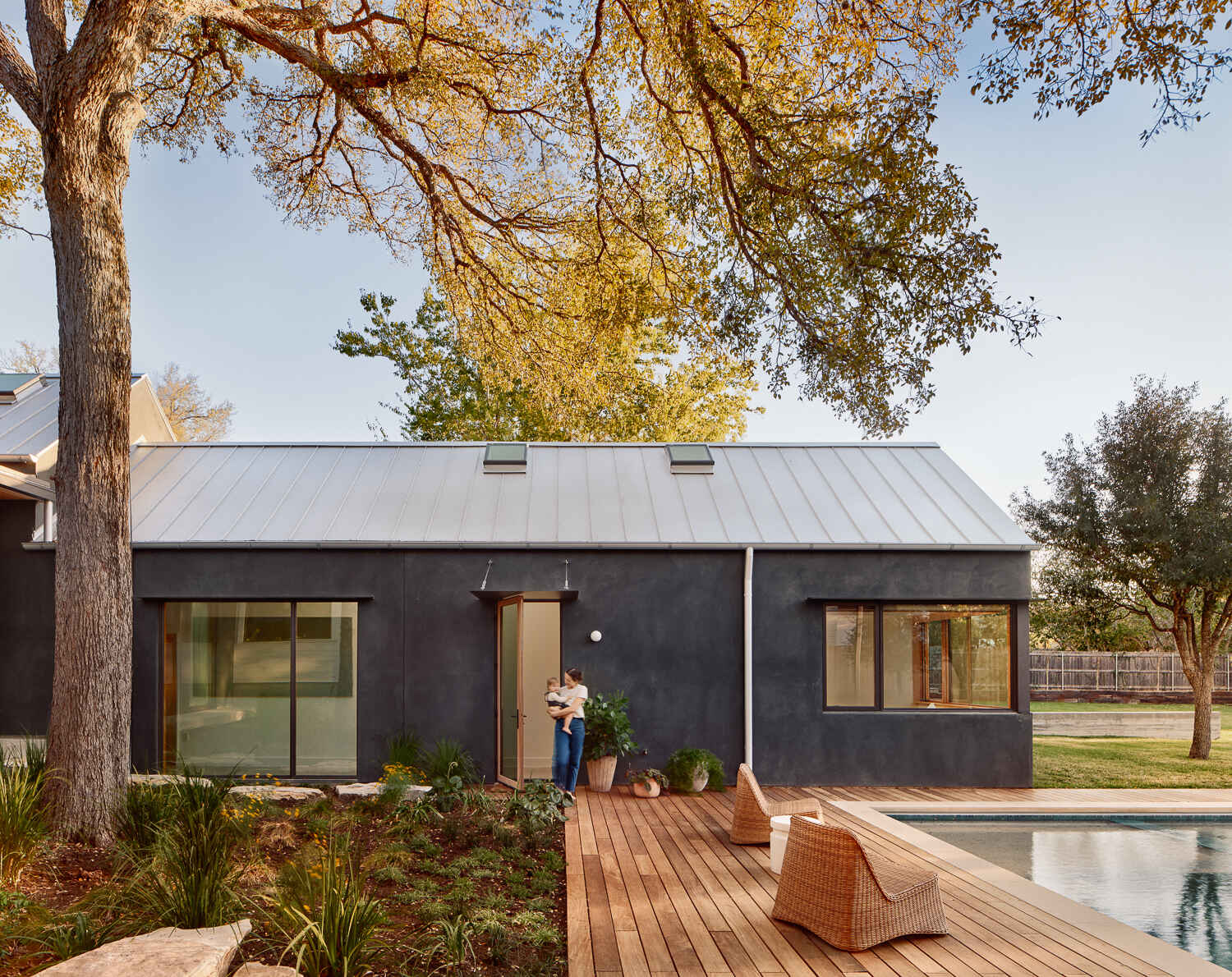 A modern wood deck surrounds the pool.