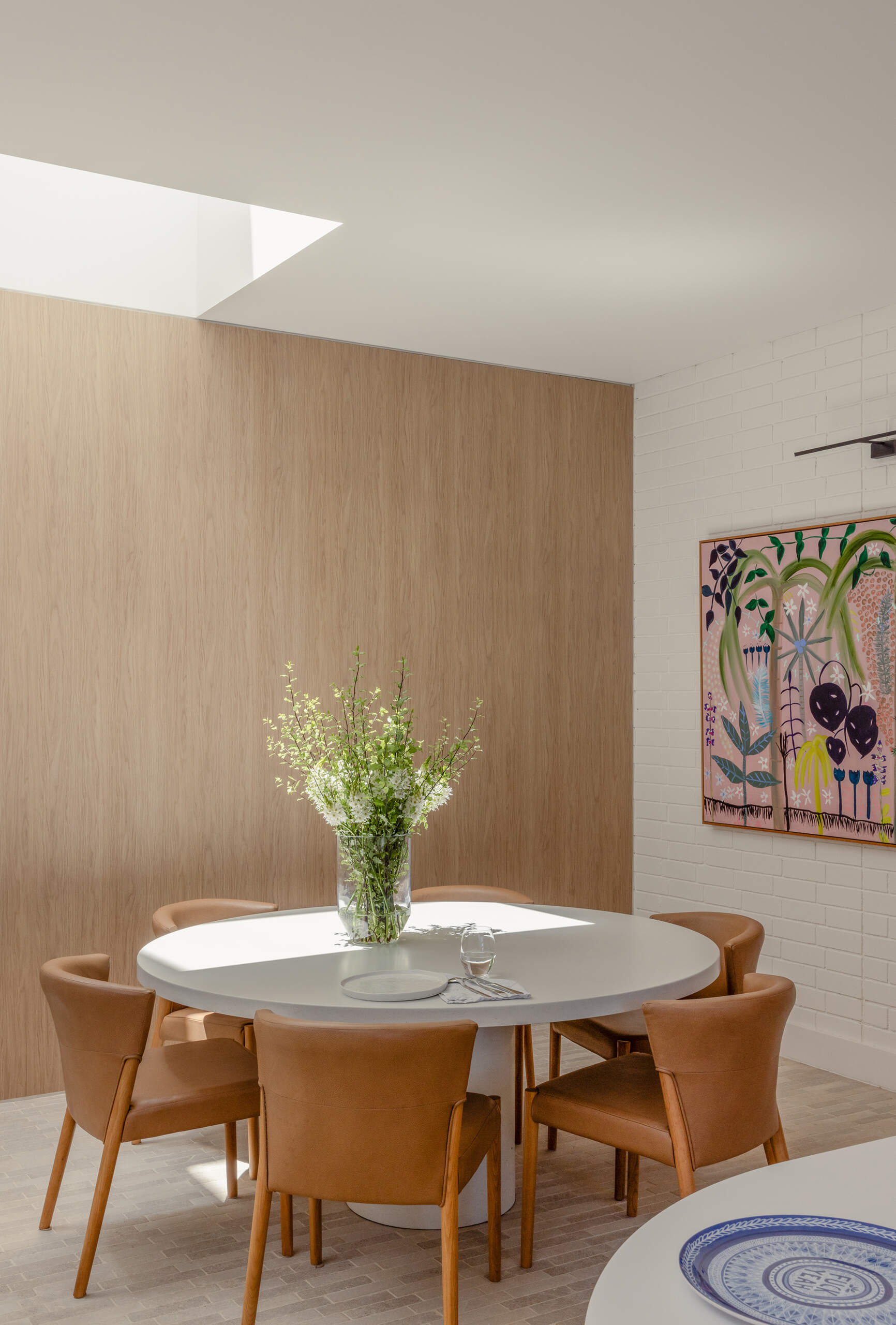 The dining area is framed by joinery that subtly separates it from surrounding spaces. It remains visually connected to the kitchen and living room.