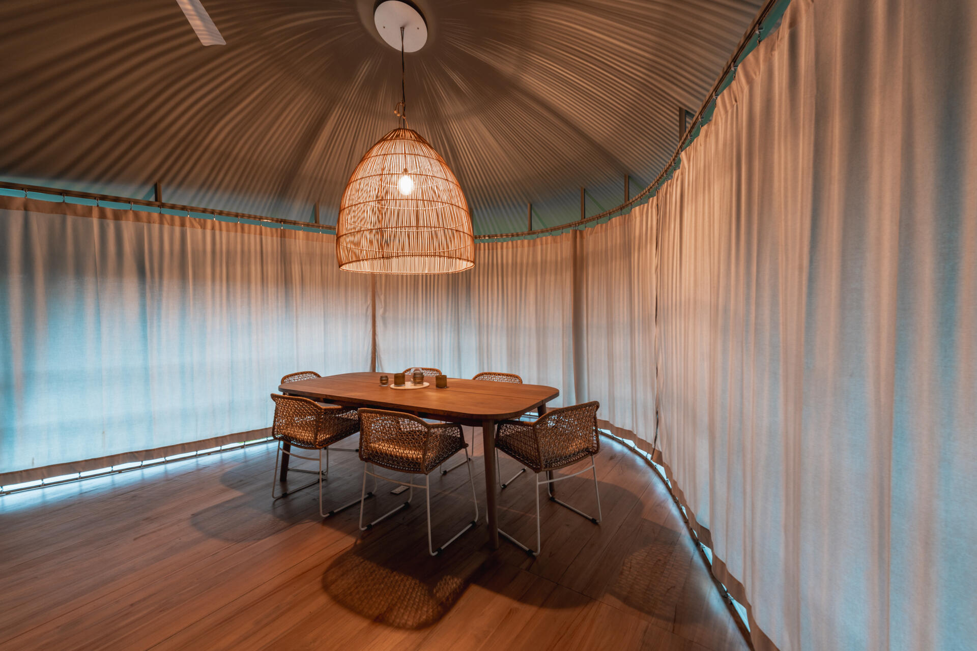 Stepping into the home, the dining area is fully open to the landscape, without windows or doors separating inside from outside. This openness supports a lifestyle centered on comfort through climate.