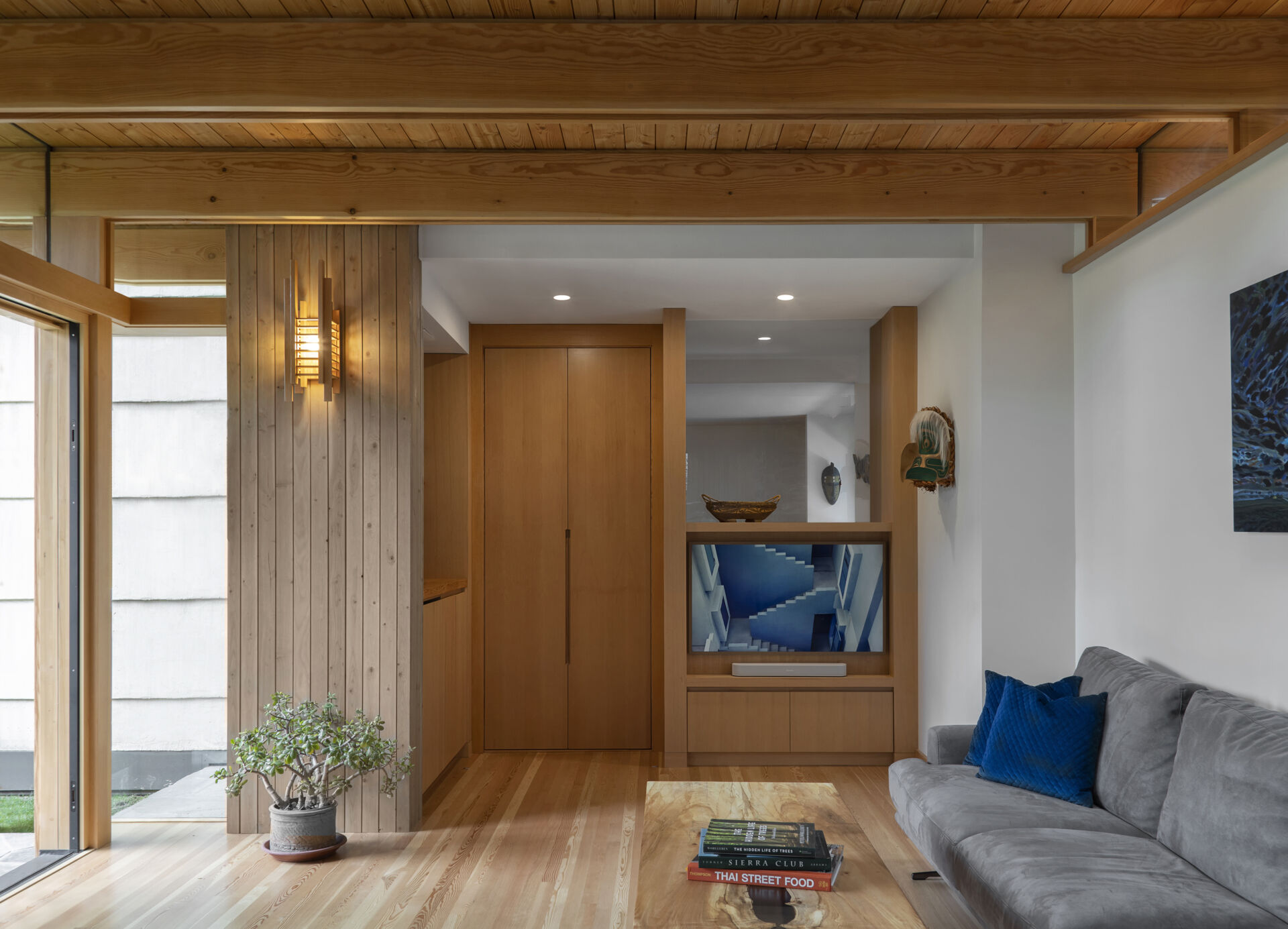 Built in seating and concealed storage allow the room to shift from work to family life, keeping the space calm, flexible, and uncluttered.