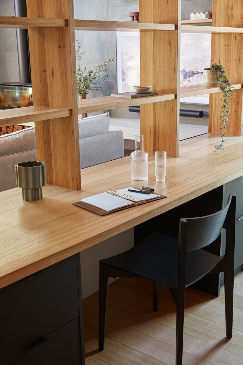 El rincón de estudio en el primer piso está parcialmente rodeado por estanterías, lo que proporciona un equilibrio entre concentración y conexión. Está ubicado dentro de un espacio que se puede abrir que permite trabajar desde casa, manteniendo la conexión visual con el espacio habitable y las vistas más allá, mientras que las particiones brindan separación sin aislar.