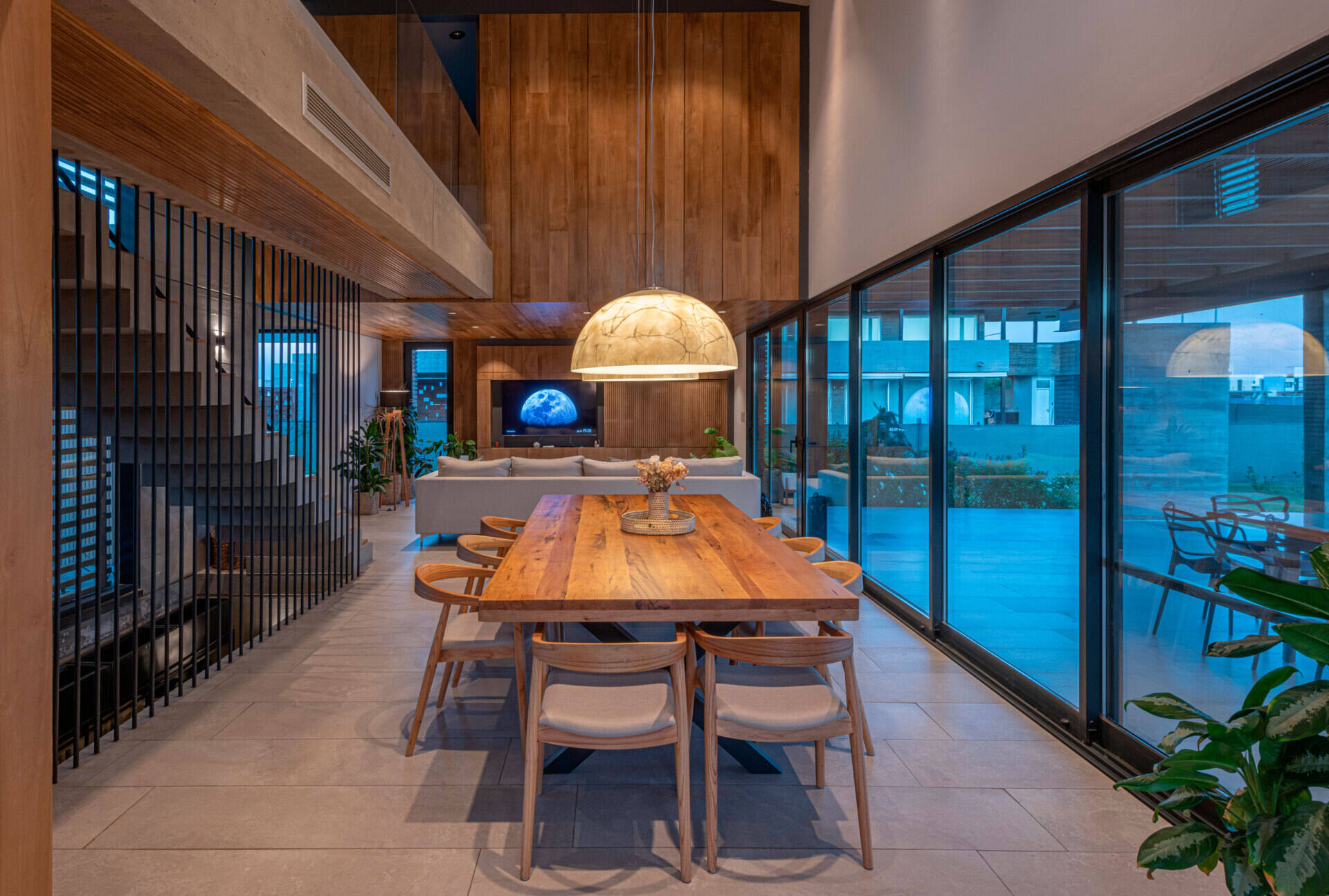 An open plan dining area that opens to a covered terrace with an outdoor kitchen and secondary dining area.