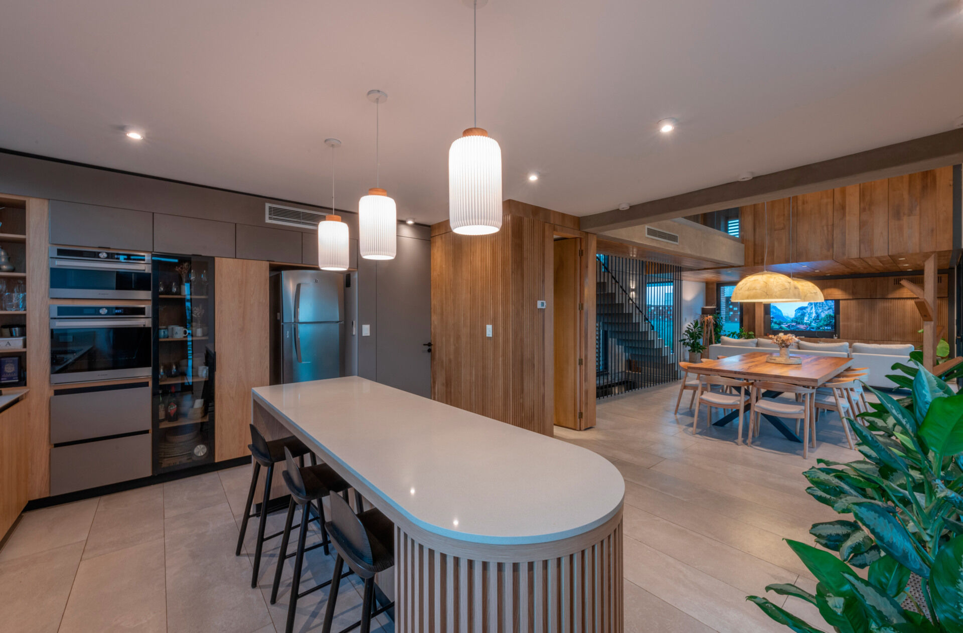A modern home with an open plan kitchen that looks out to the dining area and living room.