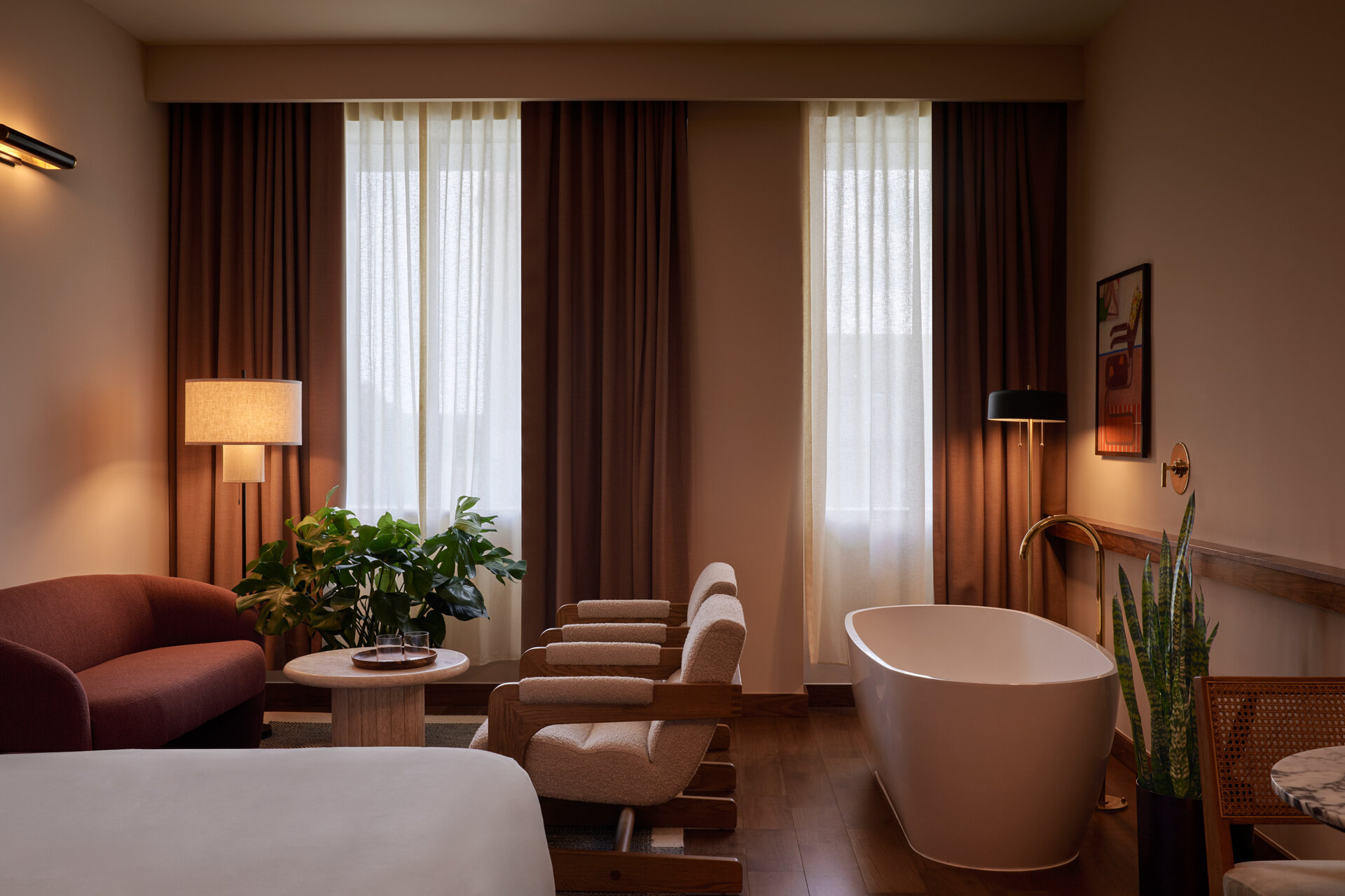 Hotel guest rooms and bathrooms blend Nordic modern influences with terrazzo floors, curved details, custom millwork, and integrated bar setups.