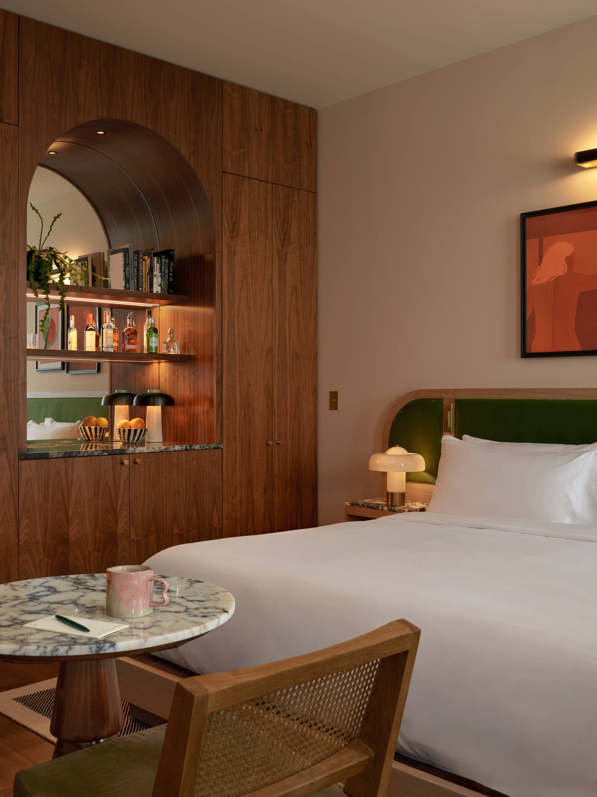 Hotel guest rooms and bathrooms blend Nordic modern influences with terrazzo floors, curved details, custom millwork, and integrated bar setups.