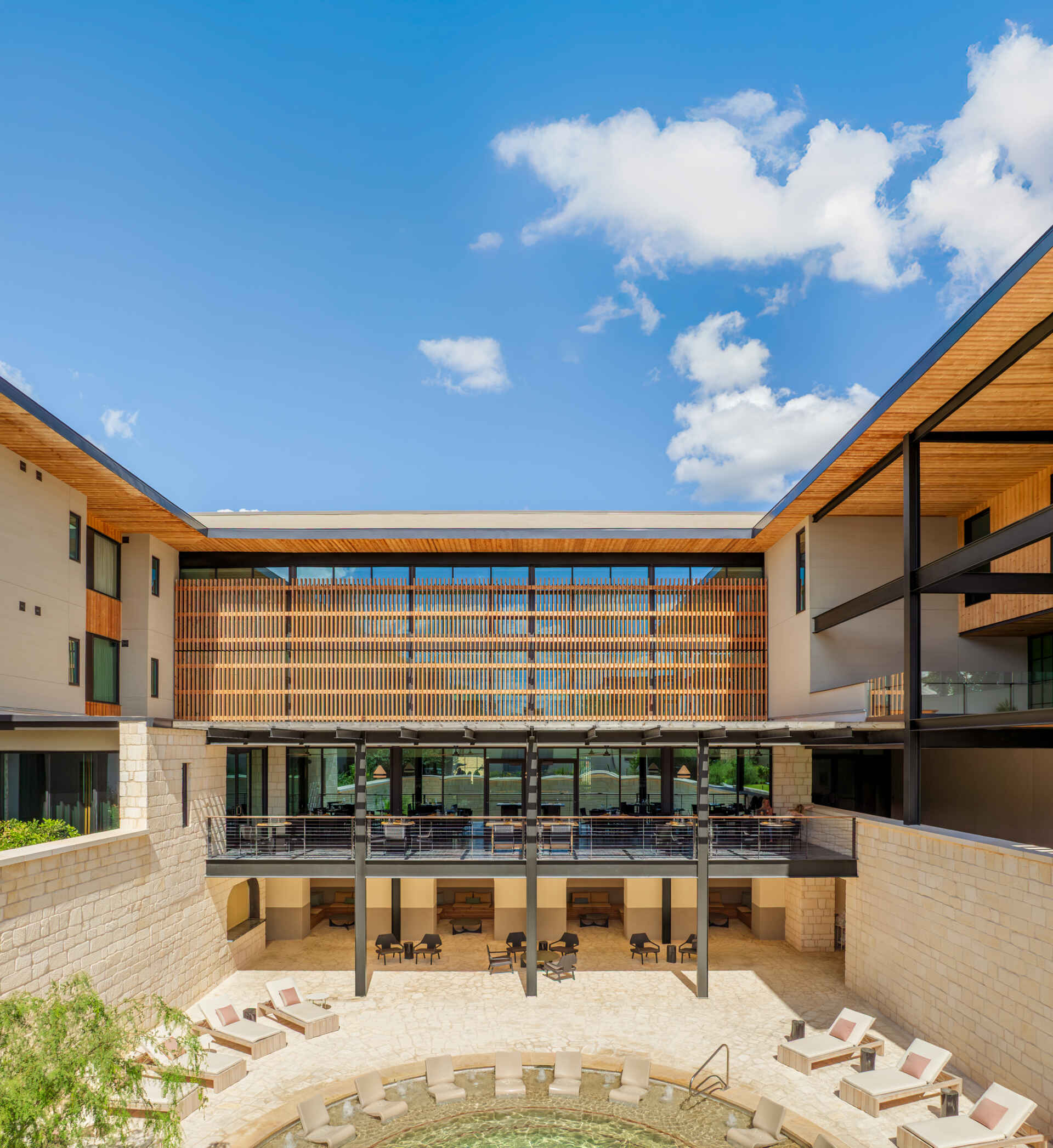 A sunken outdoor limestone pool anchors the outdoor amenities. Paired with a lounge area, it offers a sheltered place to step away from the heat while remaining within the landscape of the property.