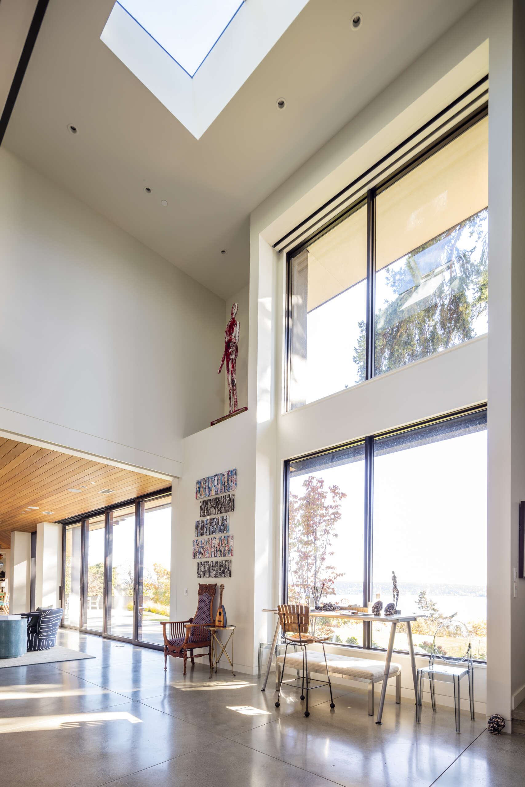A double-height art studio with skylight and transom anchors one end of the house, filling the space with natural light.