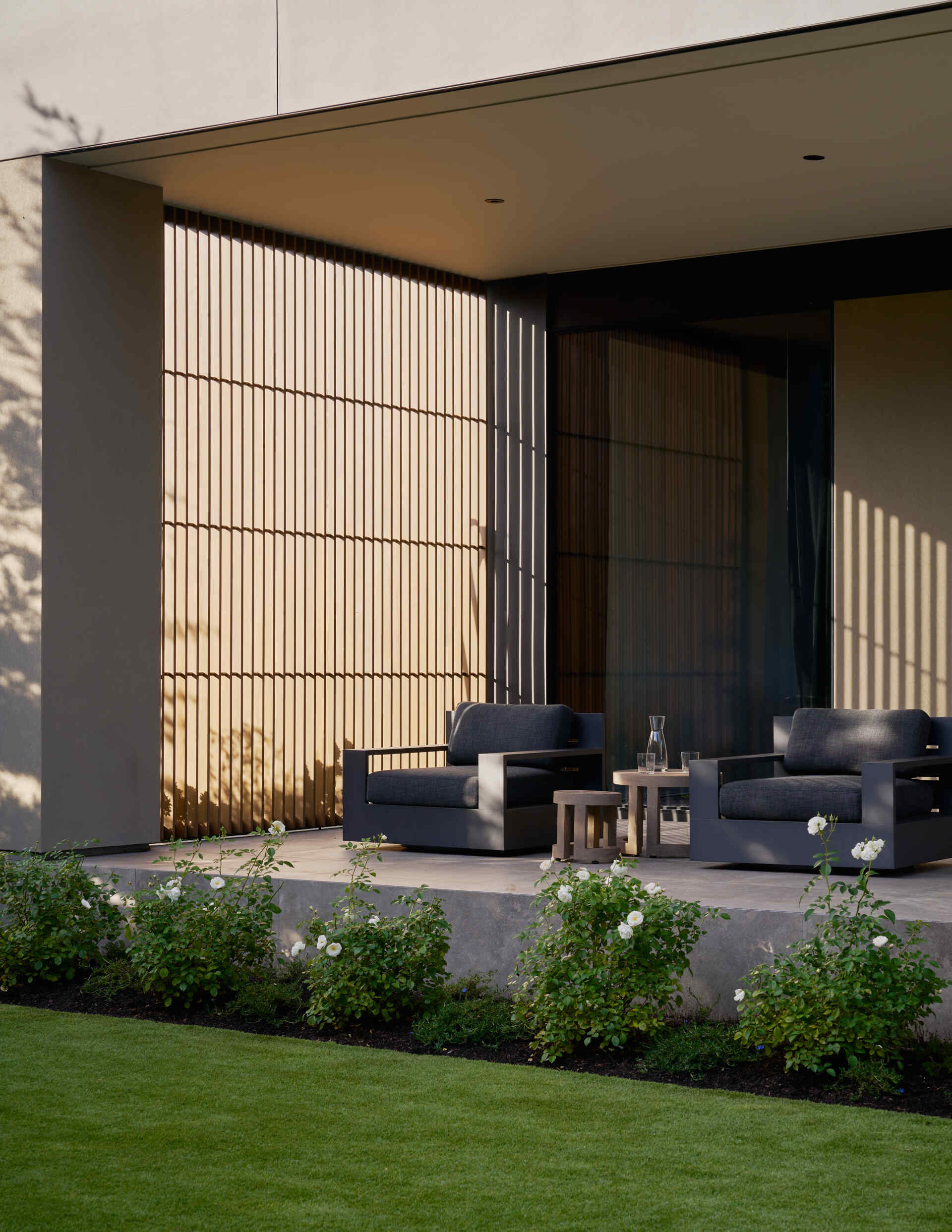 The lake-view terrace connects indoors and outdoors seamlessly, while layered screens soften views and keep the space airy.