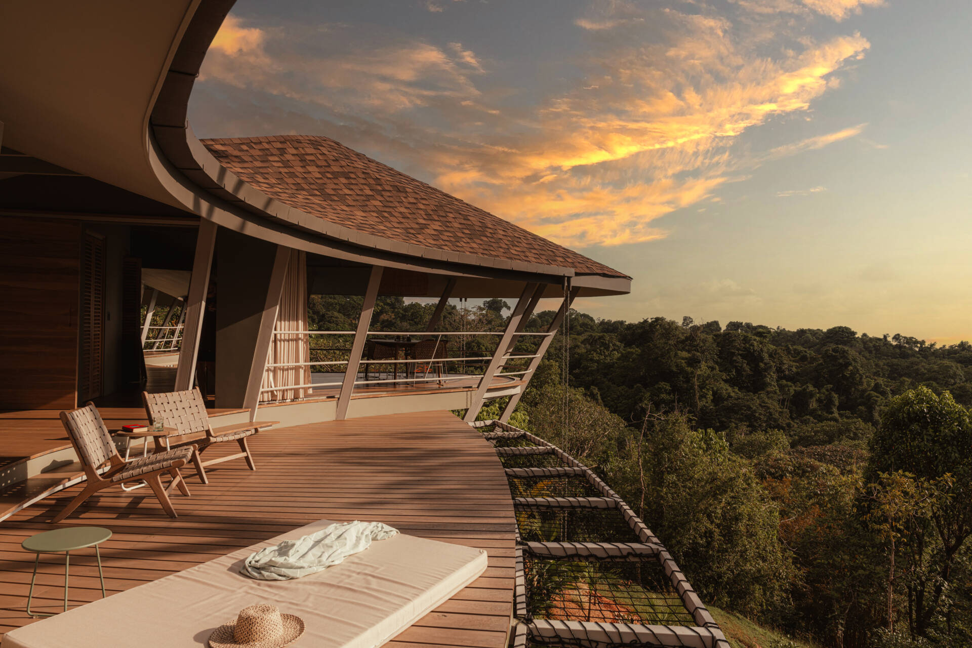 Outdoor living extends across the deck, which echoes the form of the pool. The modular structure and flowing roof shape both shaded and open areas, allowing daily life to unfold outdoors with the same architectural rhythm found inside.