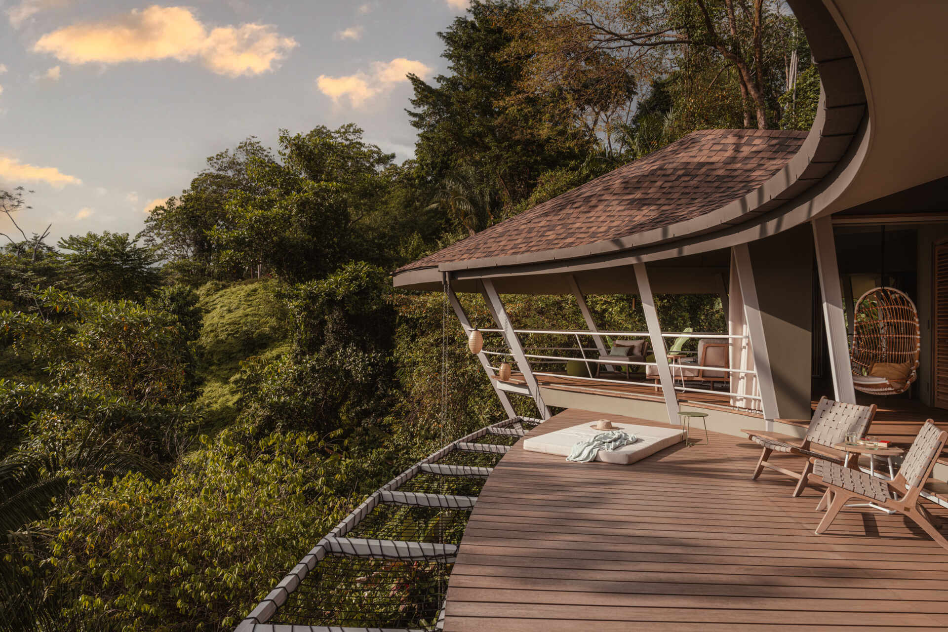 Outdoor living extends across the deck, which echoes the form of the pool. The modular structure and flowing roof shape both shaded and open areas, allowing daily life to unfold outdoors with the same architectural rhythm found inside.