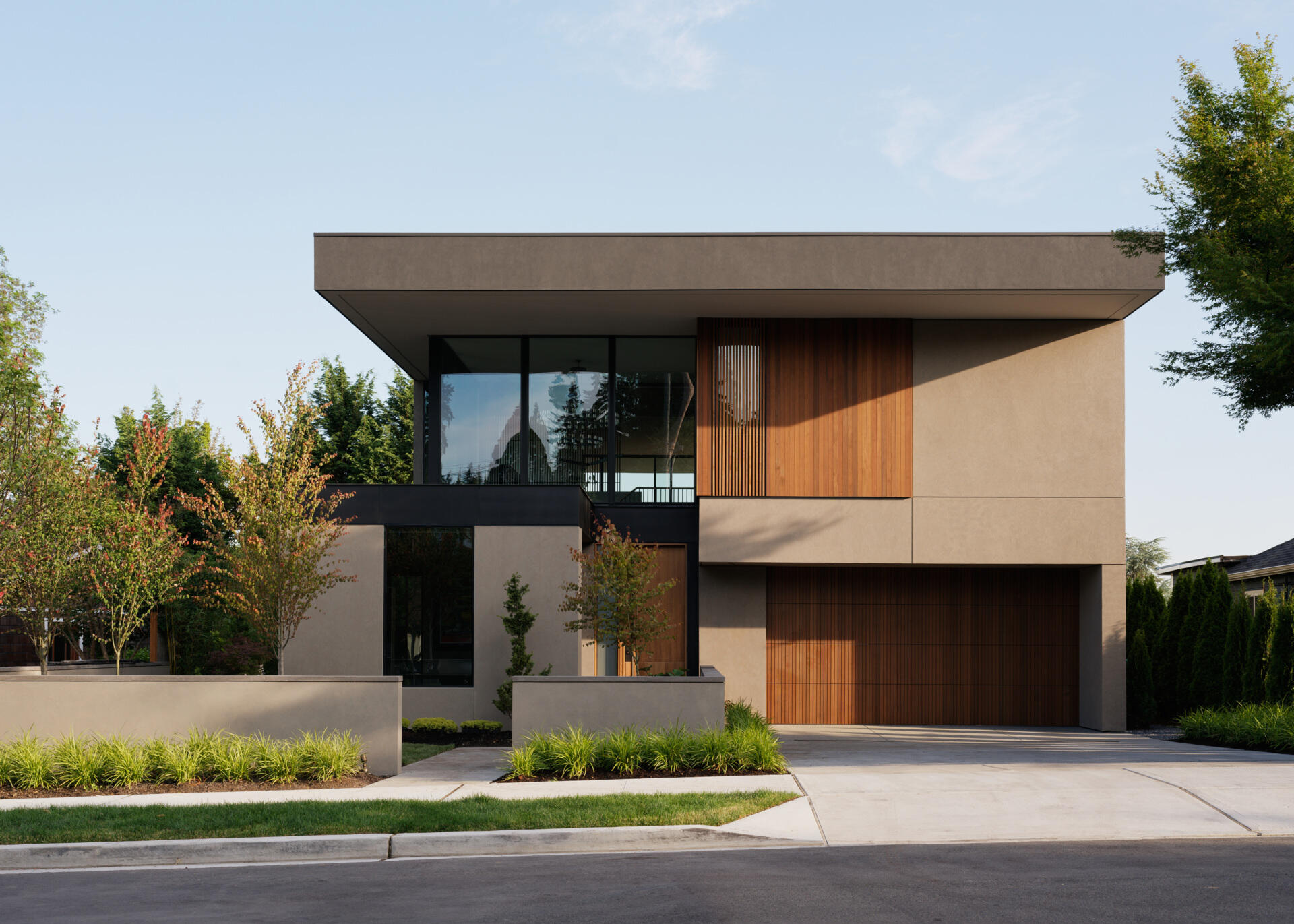 This modern home blends Pacific Northwest style with Thai-inspired wood screens. Sleek glass, steel, and warm walnut create a bright, inviting exterior.