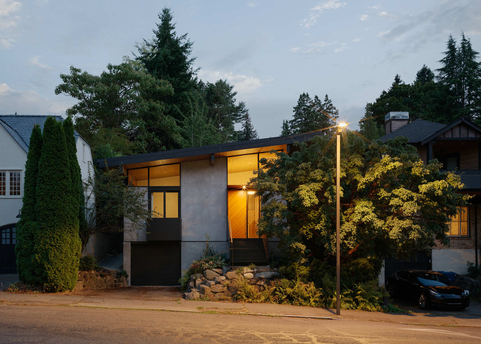 Elevated entry with stairs leads to a light-filled Seattle home with high shed roof and clerestory windows