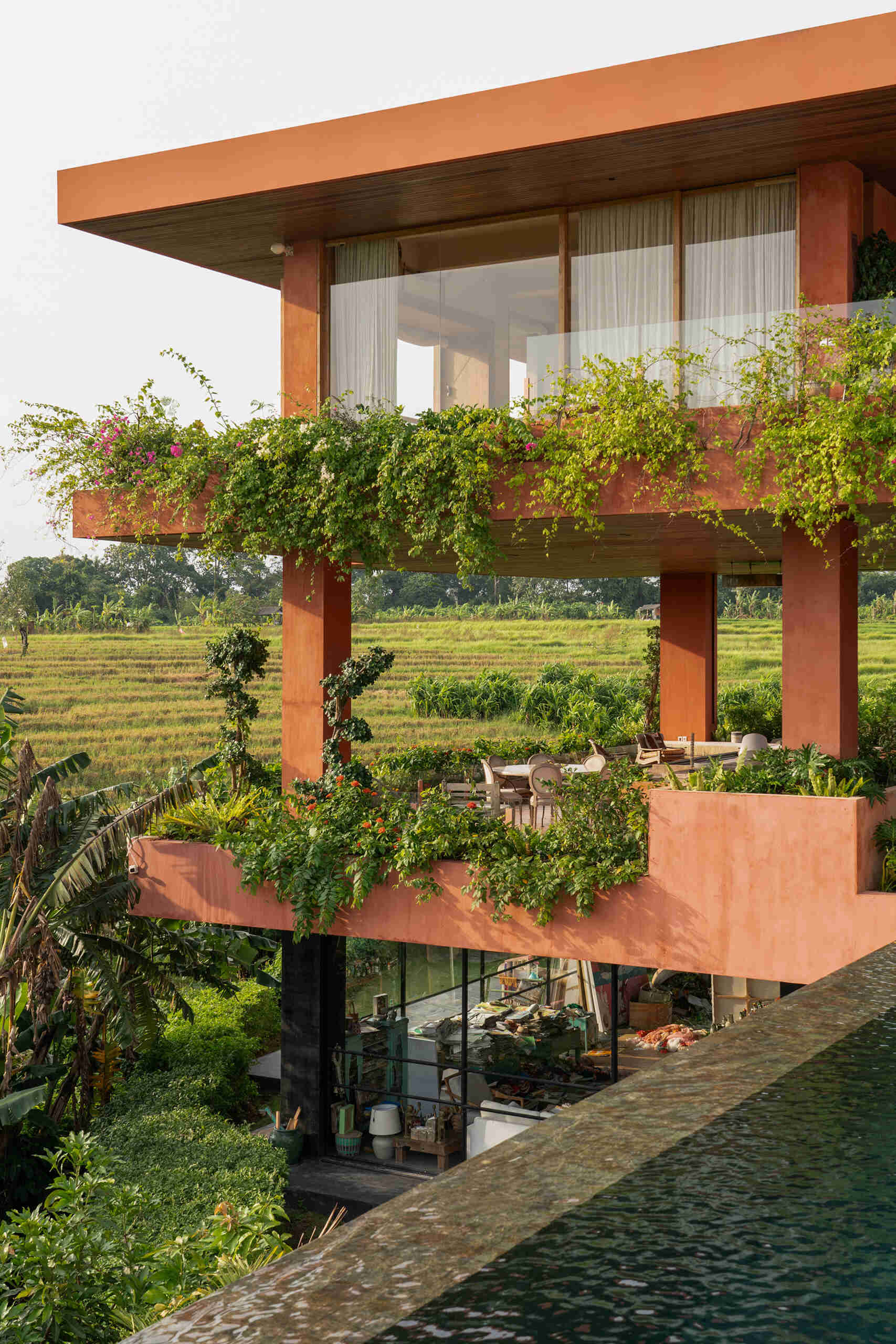 Terracotta-toned concrete, raw geometry, and warm wood define this brutalist house designed to frame art rather than compete with it.