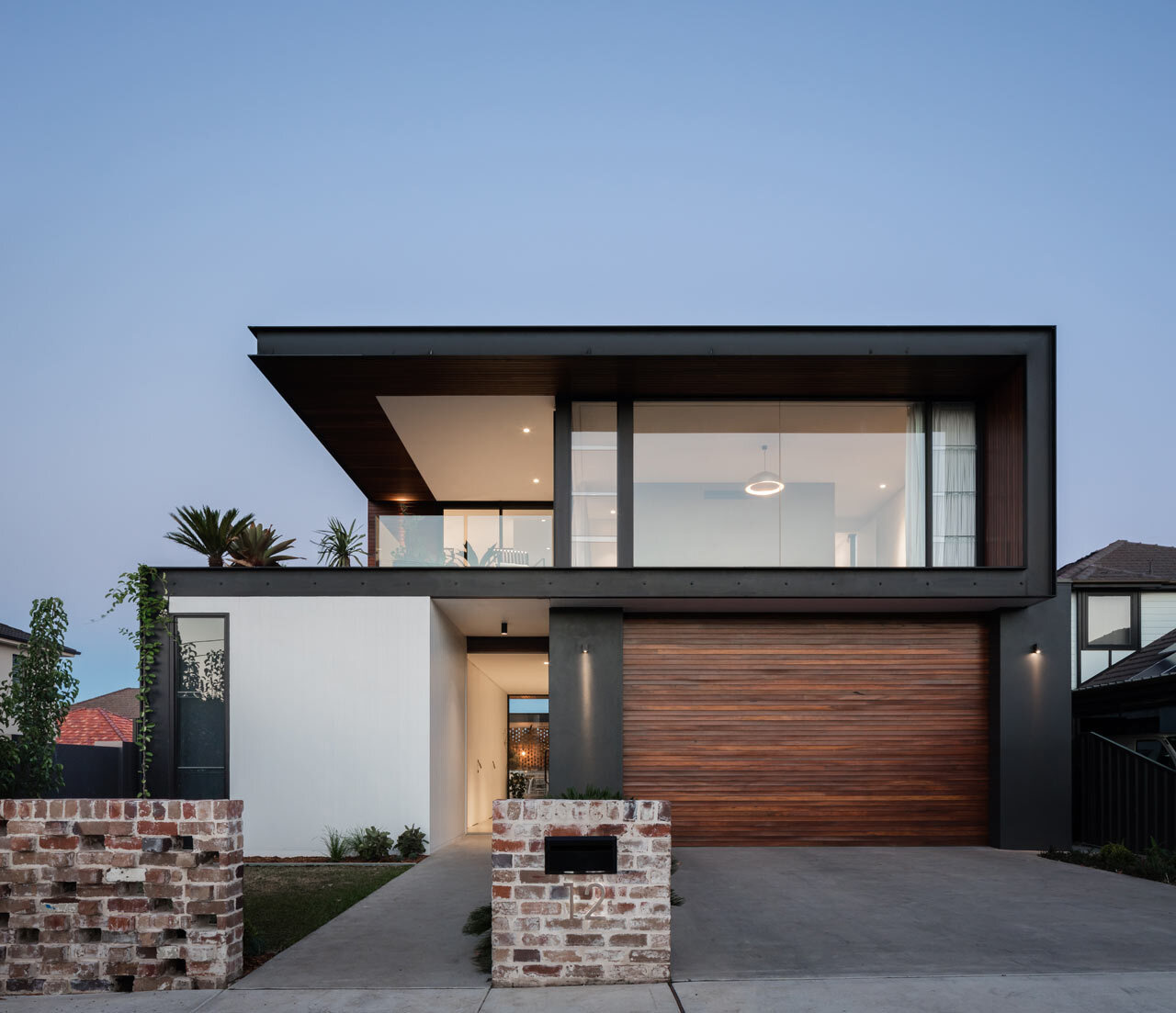 Industrial materials like concrete, recycled brick and black steel combine to create a modern yet warm family home.