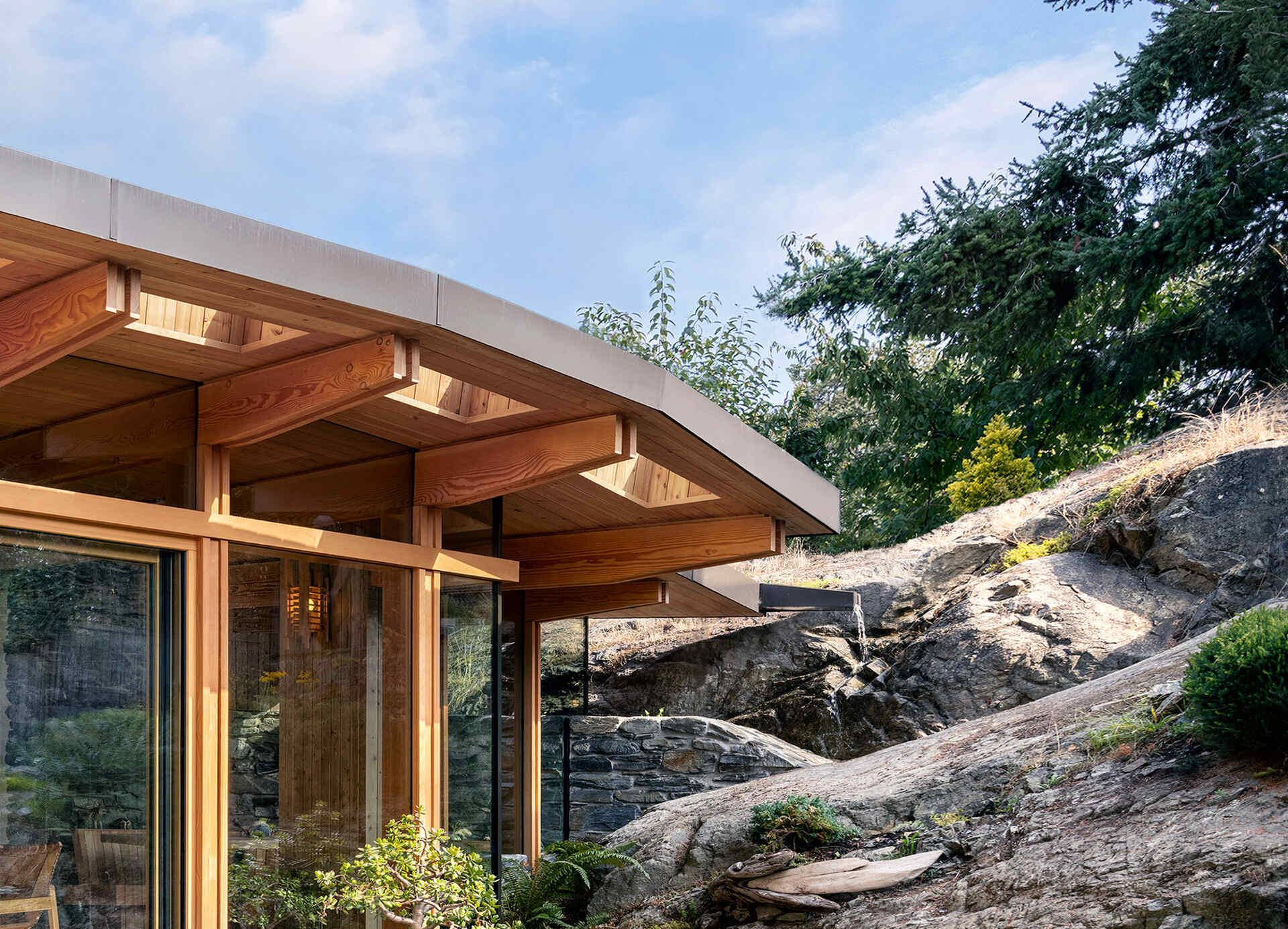 Island sourced timbers, stone from the site, and passive solar overhangs create a structure rooted in place and tuned for year round comfort.
