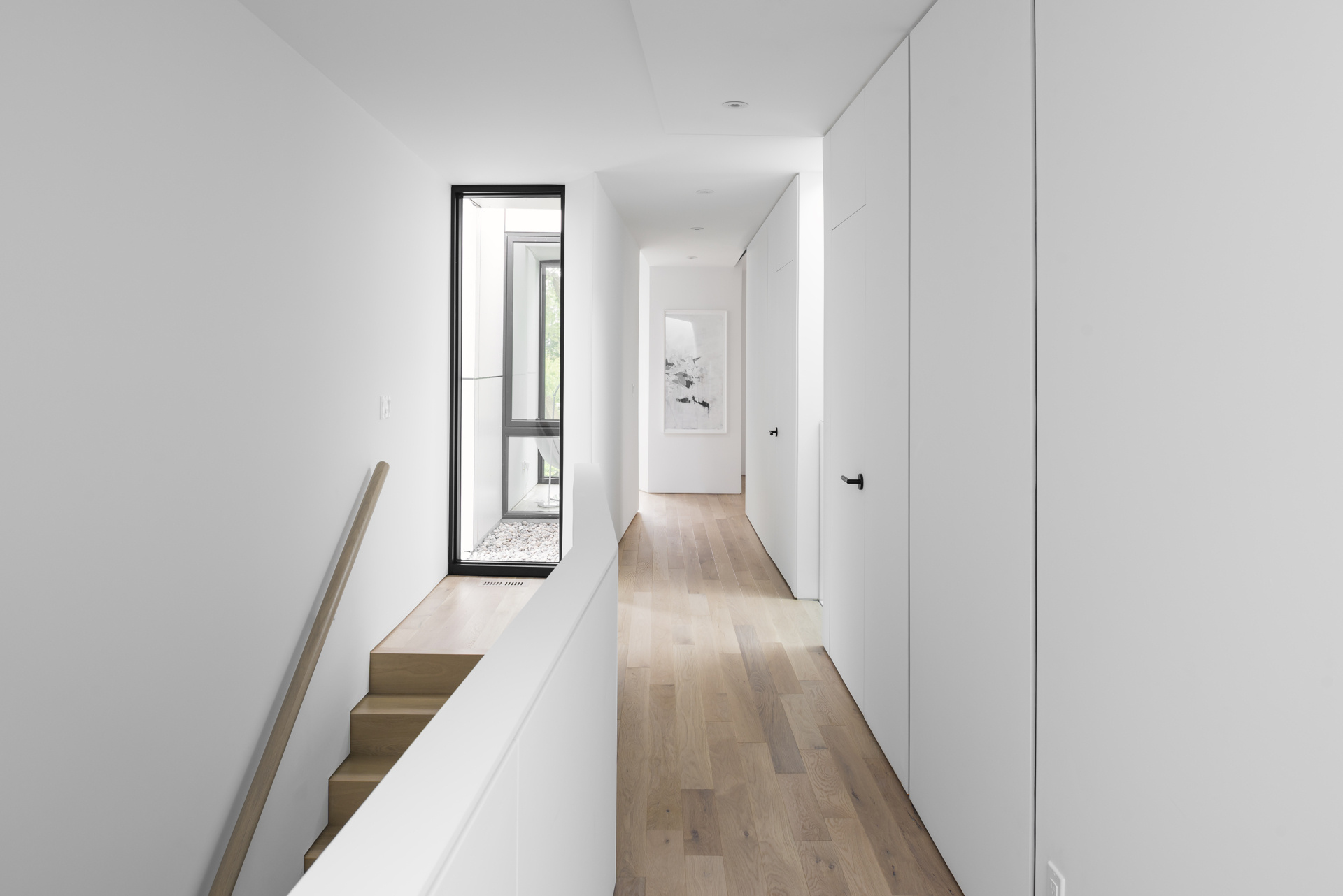 Architectural voids at the top of the stairs allow natural light to flow through multiple levels of the home.