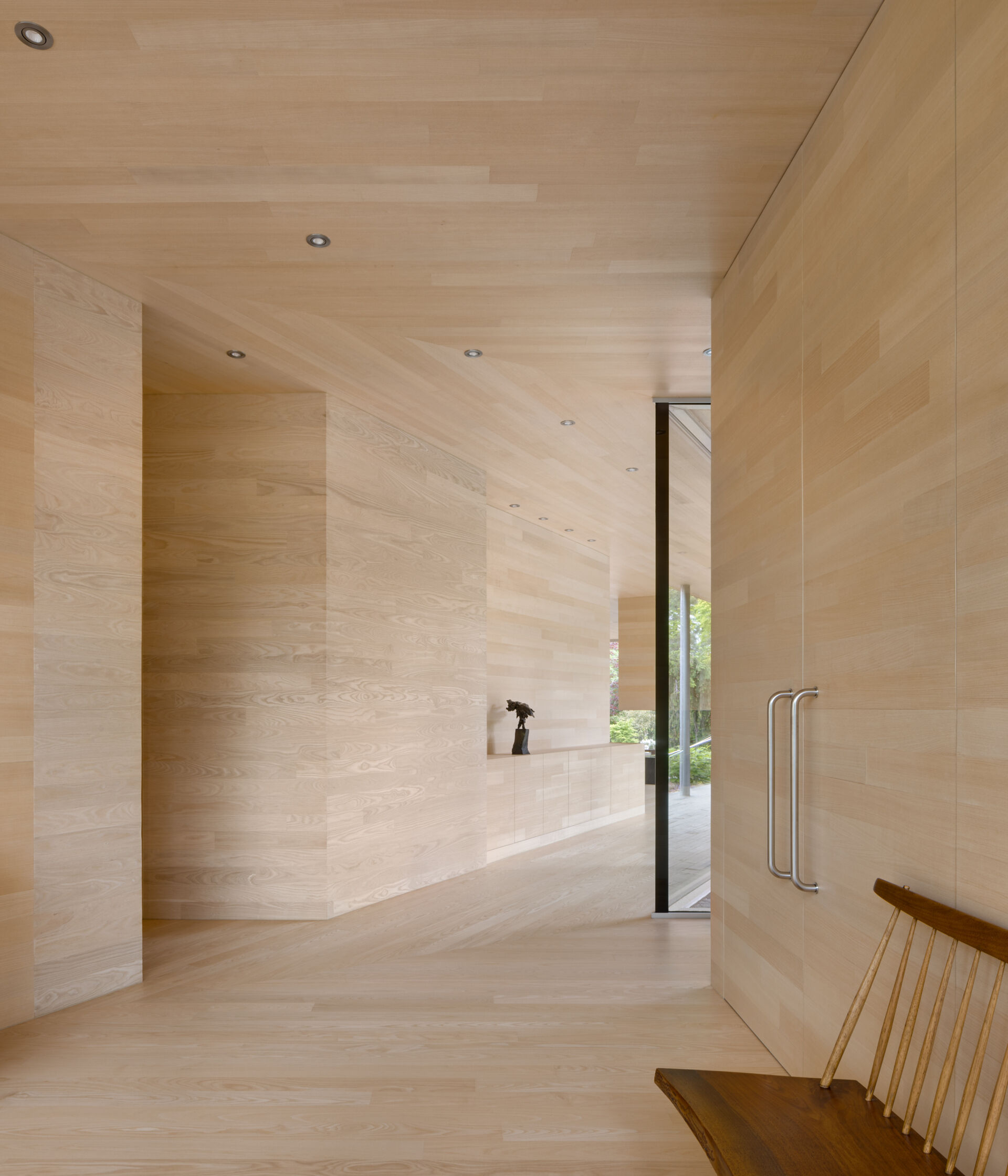 La entrada principal orientada al sur está cuidadosamente alineada con el movimiento estacional del sol. En invierno, la luz del sol llega profundamente al espacio. Durante los meses más cálidos, la entrada permanece a la sombra. Cada abertura en el exterior de pizarra revela la calidez del interior de madera, marcando claramente la transición del exterior al interior.