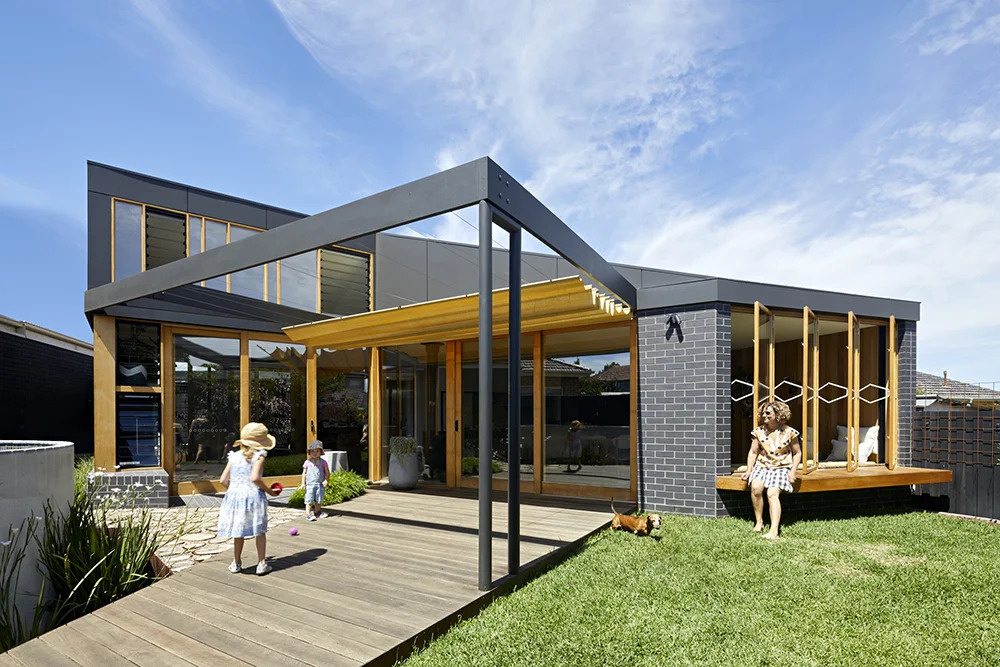 This clever extension tucks under the existing eaves, wrapping around the original home and uniting old and new with a continuous roofline.