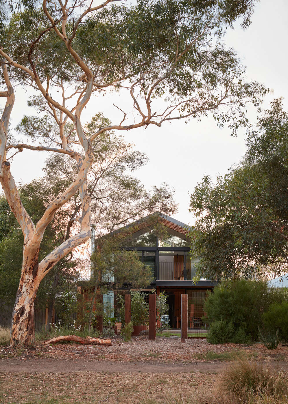 La valla trasera transparente permite vistas sin obstáculos del parque. En lugar de cerrar la frontera, la extensión abarca su exposición. La plantación en capas y las formas construidas suavizan esta relación, creando profundidad y privacidad sutil sin bloquear completamente la vista.