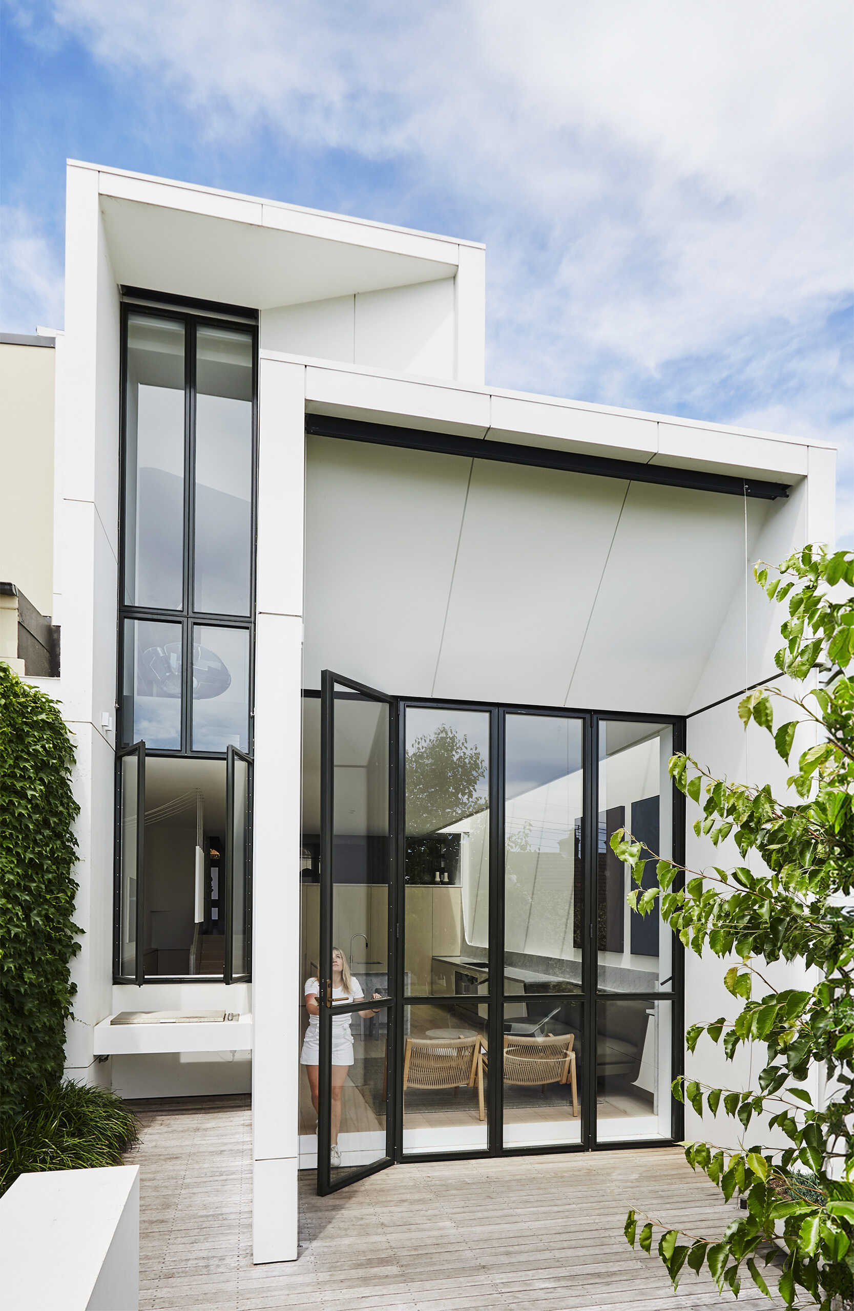 Las puertas corredizas abren completamente el espacio habitable al jardín, permitiendo una convivencia perfecta entre el interior y el exterior.