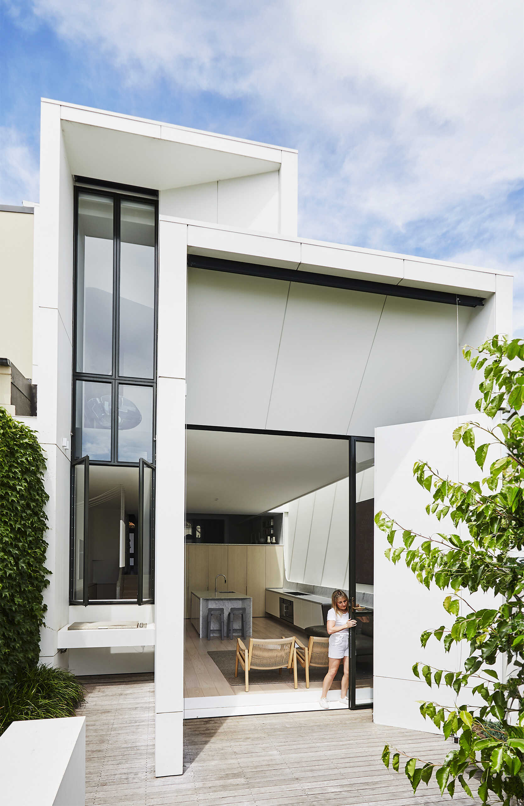 Las puertas corredizas abren completamente el espacio habitable al jardín, permitiendo una convivencia perfecta entre el interior y el exterior.