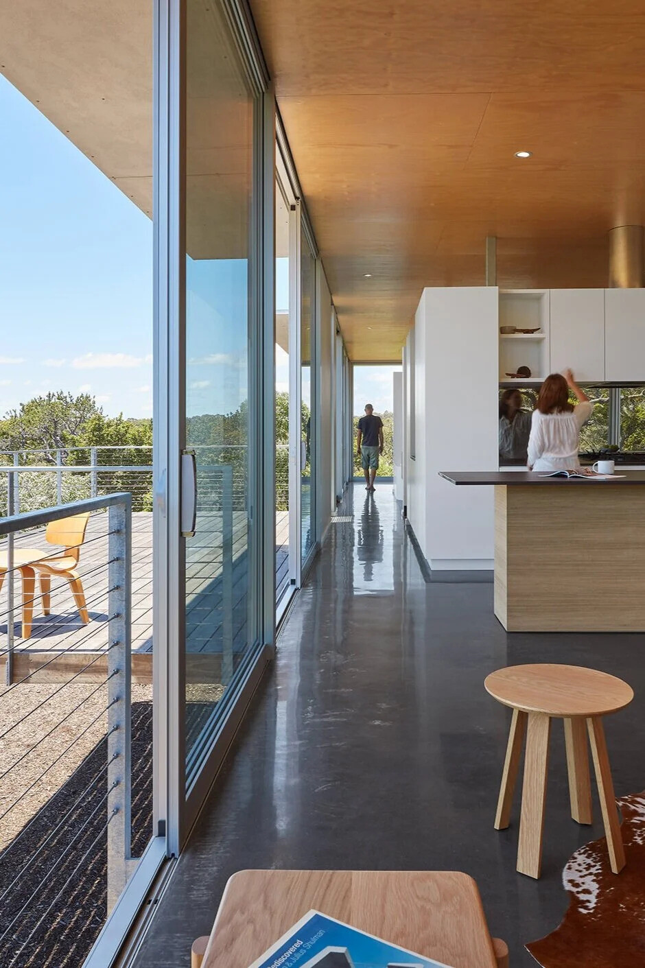 A modern elevated home with no internal doors and a central pod that enhances visual flow throughout the upper floor.