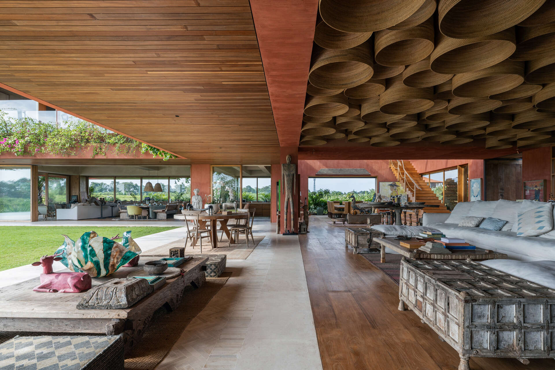 Vintage artworks, carved wooden pieces, and filtered daylight shape the main living spaces of this art-focused home.