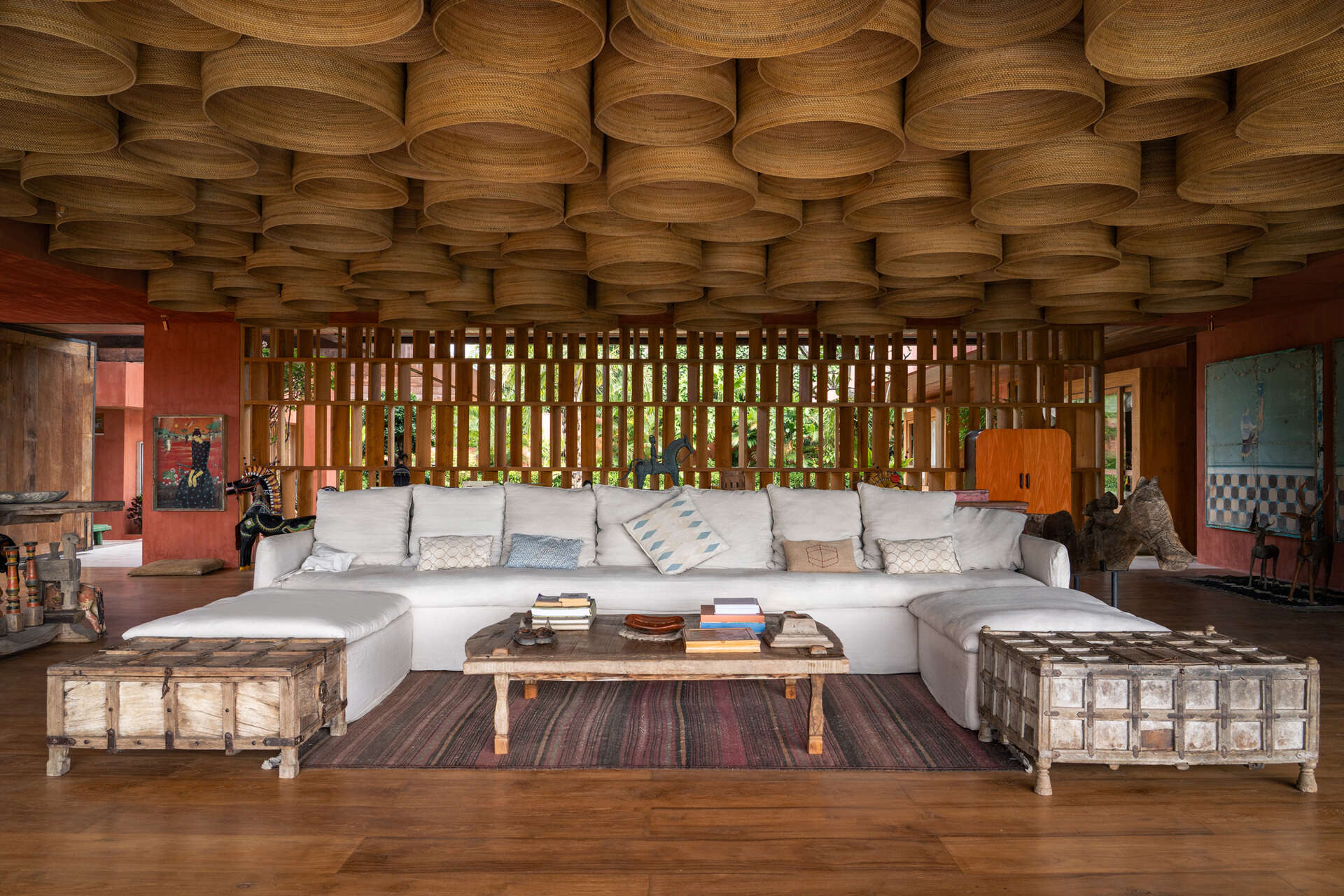 Vintage artworks, carved wooden pieces, and filtered daylight shape the main living spaces of this art-focused home.