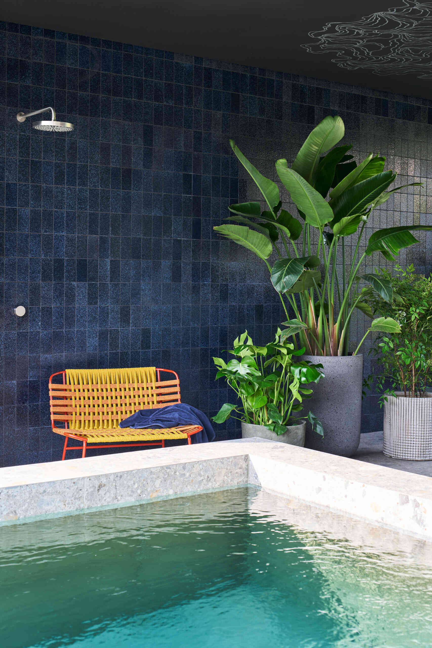 A modern house with a patio, swimming pool, and firepit.