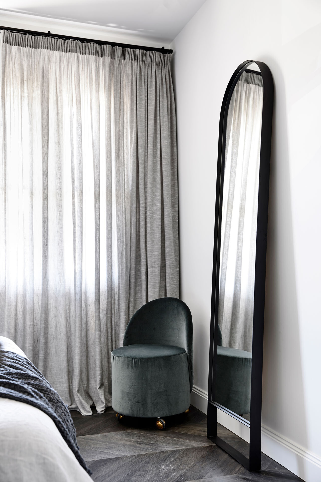 Soft morning light, a velvet upholstered headboard and a calm, layered palette create a peaceful master bedroom that feels both refined and welcoming.