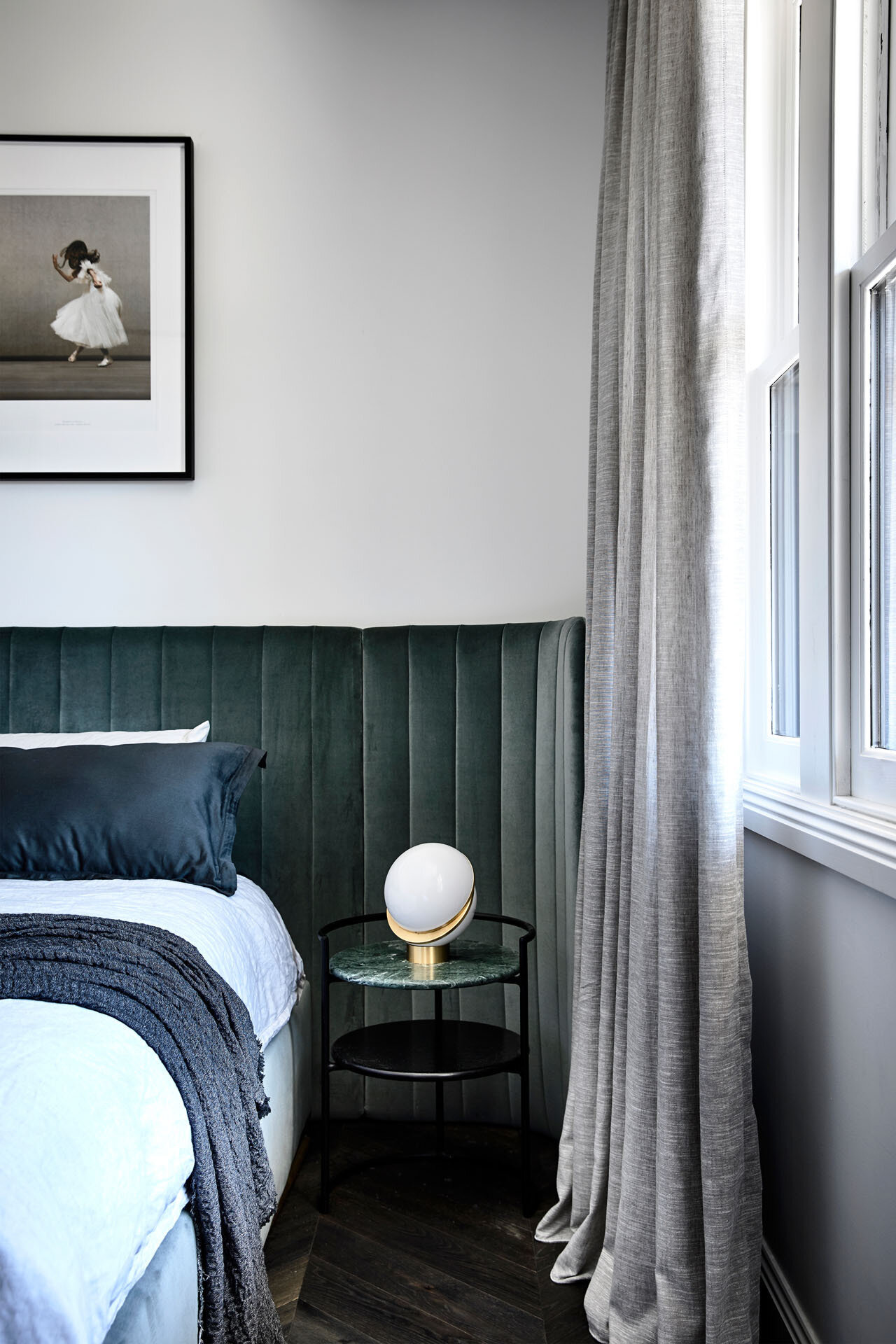 Soft morning light, a velvet upholstered headboard and a calm, layered palette create a peaceful master bedroom that feels both refined and welcoming.
