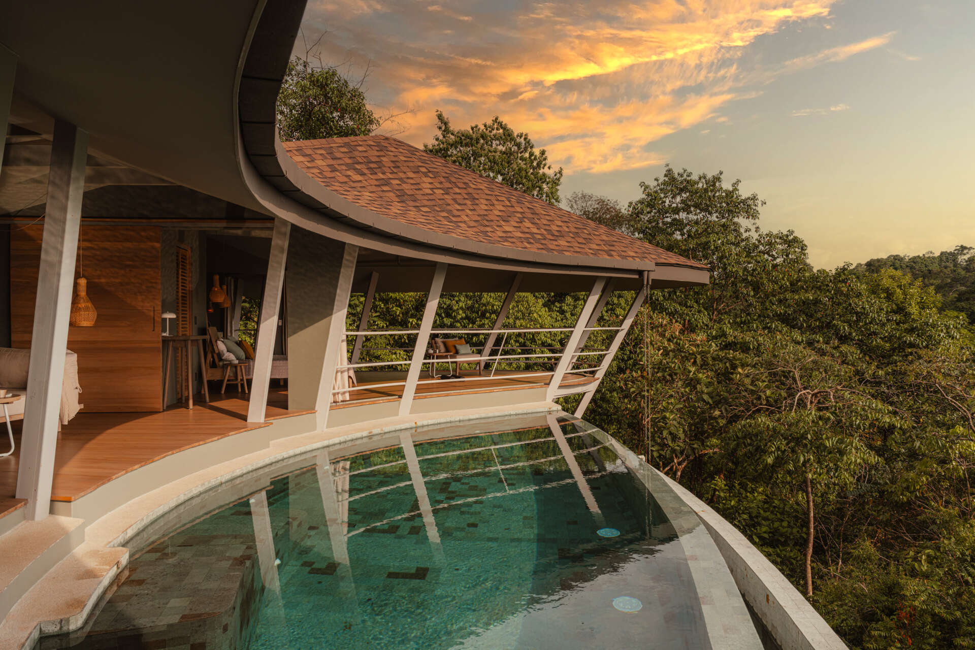 The pool stretches toward the horizon, blending visually with the sky and ocean beyond. From above, its circular reflection forms an eye-like shape, inspiring the name Ojo de Nila. This gesture reinforces the idea of the home as an observer of its surroundings, always engaged with the landscape it inhabits.