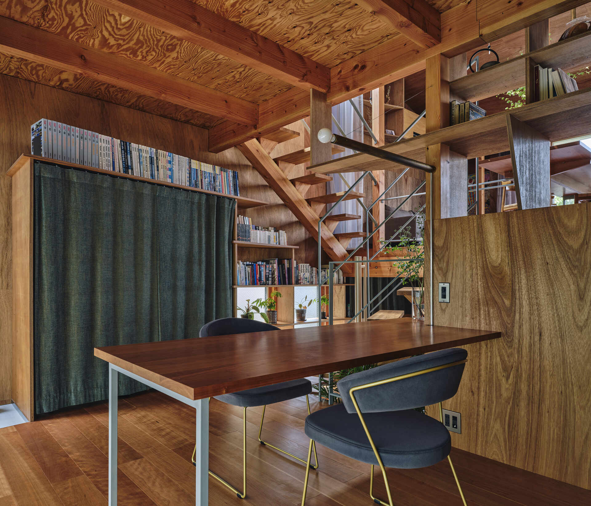 This home office is woven into the daily flow of the house, where split levels, displayed objects, and garden views shape a calm, thoughtful place to work within a dense Tokyo neighborhood.