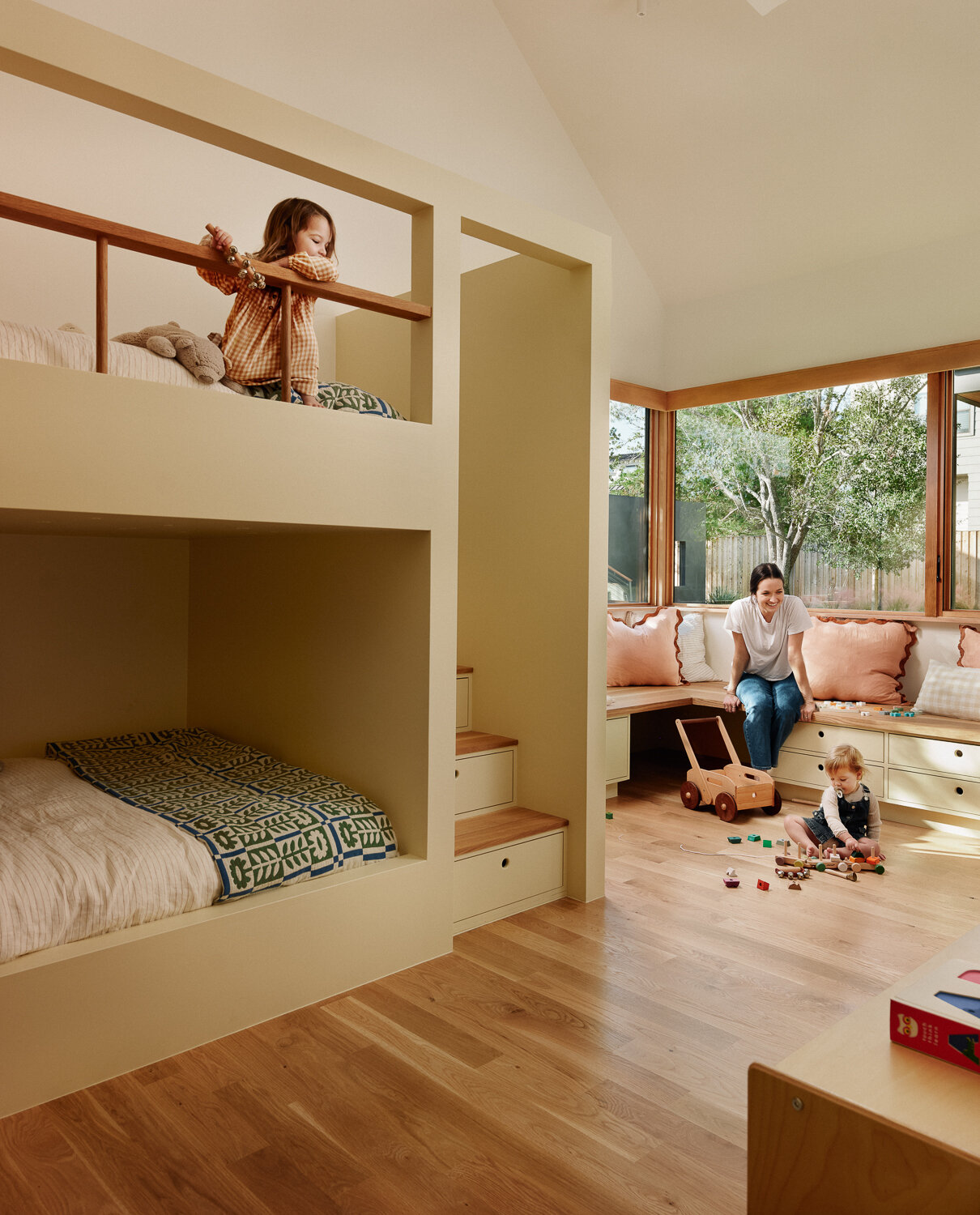 The kids’ room is designed to support both rest and play. Built-in bunks are tucked into cozy niches, and storage drawers are built into the steps and beneath the window seat, keeping books, blankets, and toys within easy reach.