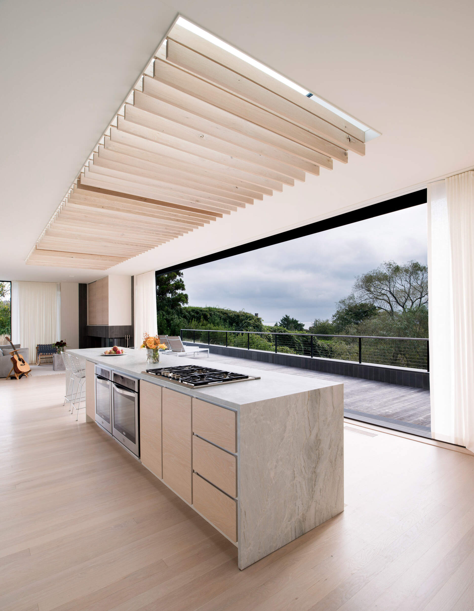 Las contraventanas de roble bajo el tragaluz de gran tamaño se mecen con la brisa del mar, proyectando luces y sombras en constante cambio, aportando movimiento y calma al interior.