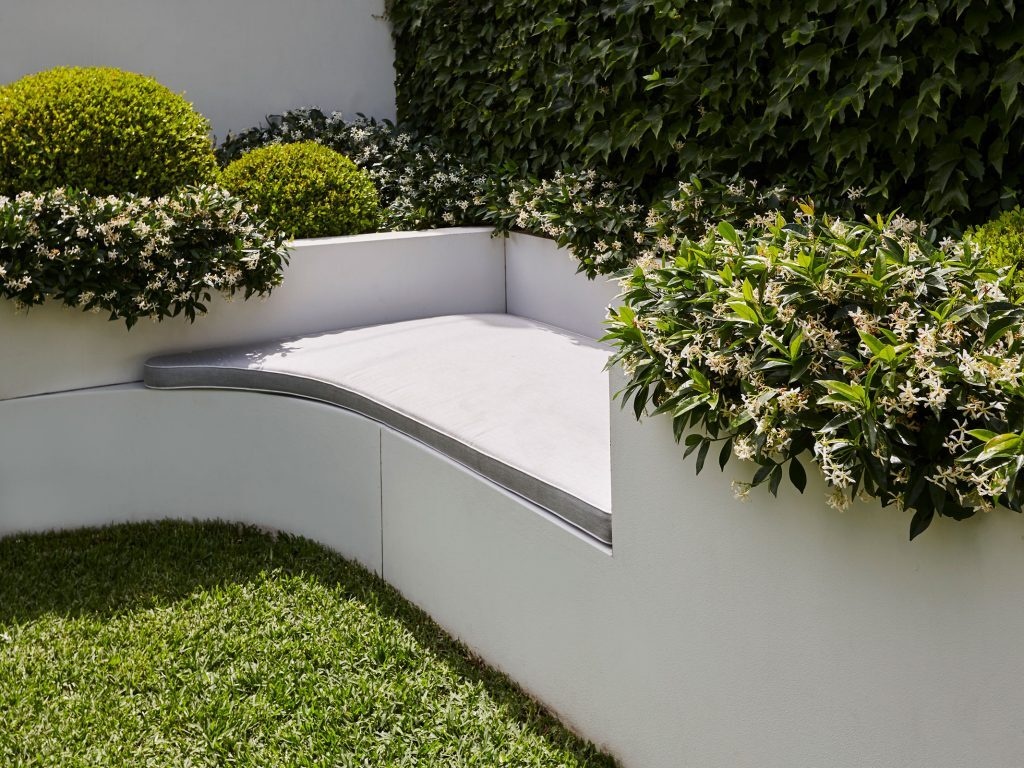 Los asientos al aire libre incorporados convierten el jardín en una extensión de la casa.