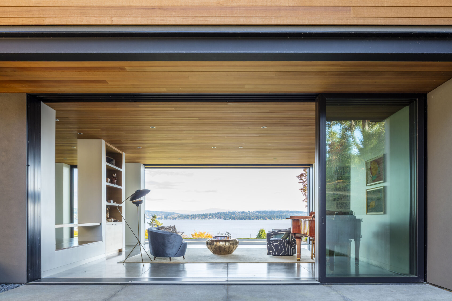 Sliding glass doors on both sides of the main living space flood the interior with light and connect the house to its surroundings.