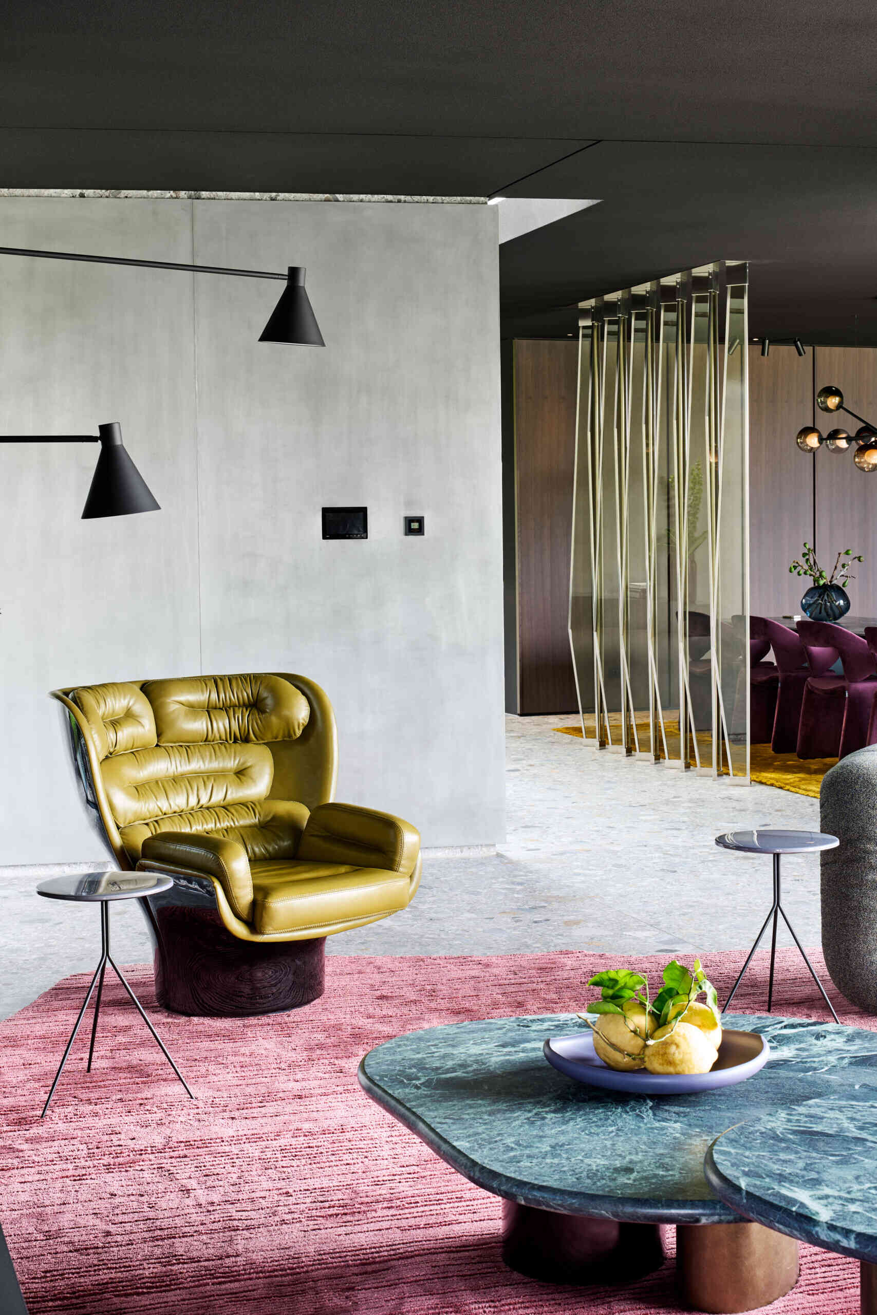 In this living room, a black ceiling stretches across the space, immediately setting the tone. It allows color and material to step forward, turning furniture and sculptural objects into characters within the room. Each element stands on its own, yet remains part of a carefully balanced composition.