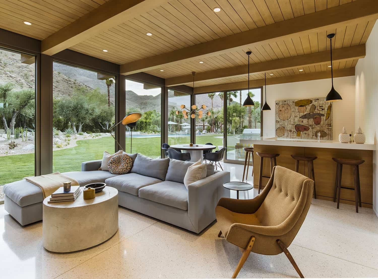 A relaxed secondary living room with a bar and casual dining area in a mid century renovation.
