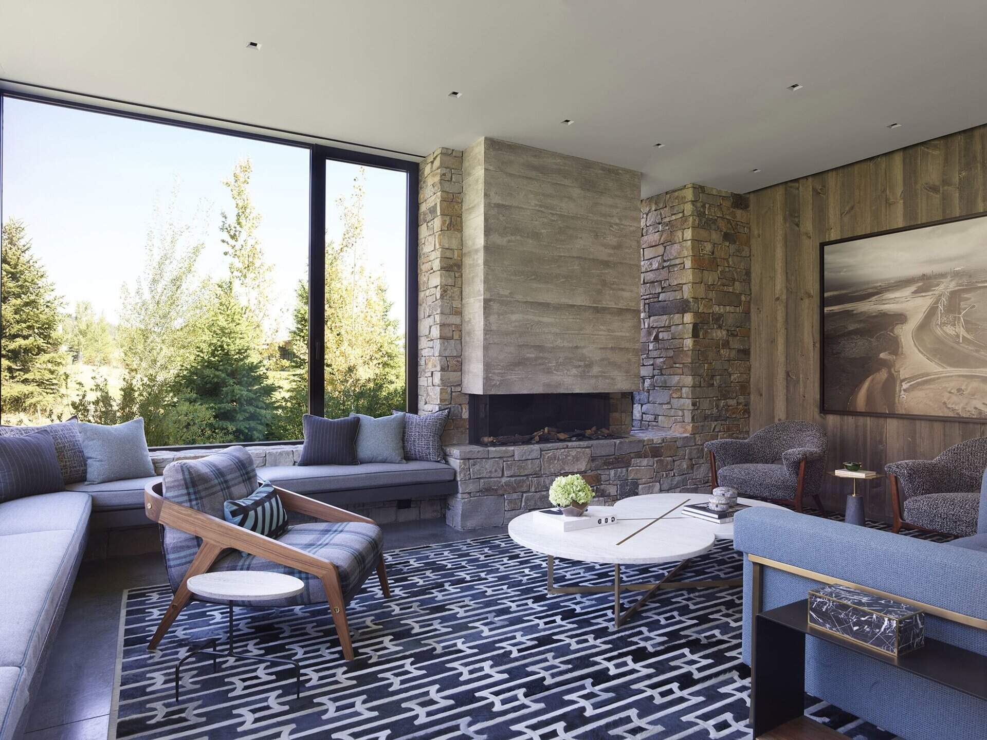 La segunda sala de estar del piso de arriba cuenta con un banco junto a la ventana y una chimenea diseñados para brindar un refugio relajante para pasar tiempo en familia.