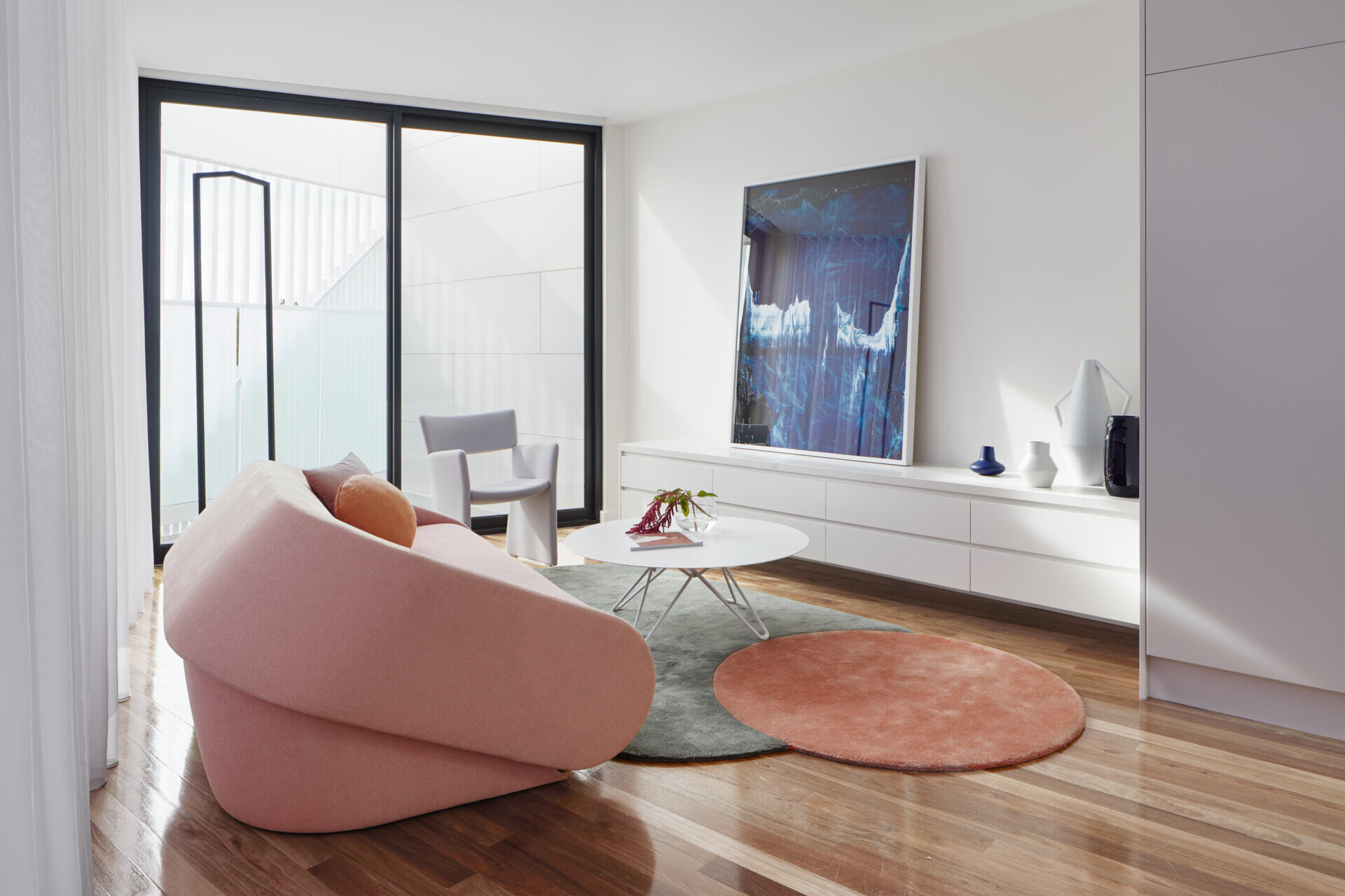 The open-plan upper floor provides airy living space, protected by a floor-to-ceiling curtain that balances light and privacy.