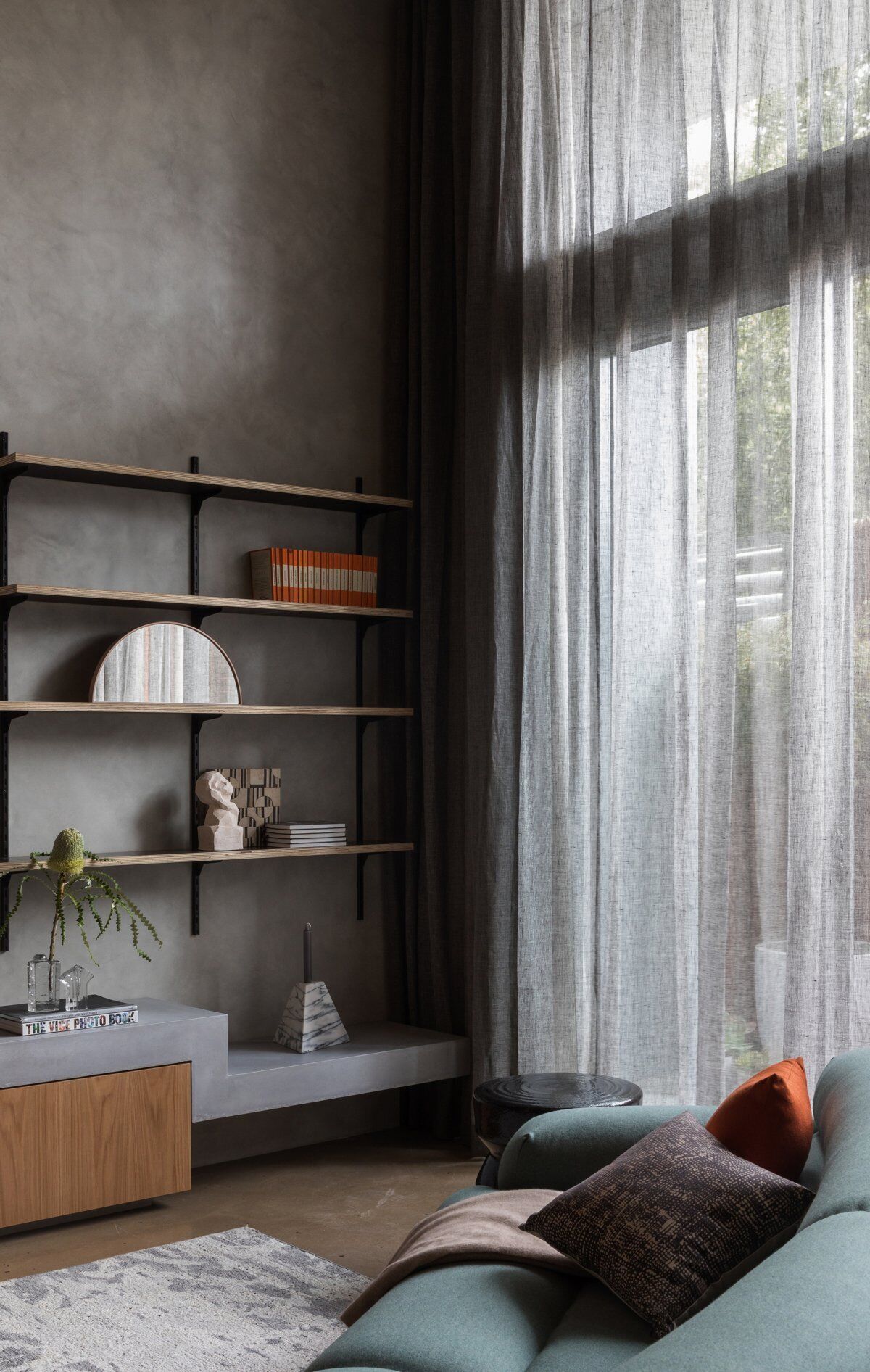 Las espectaculares paredes de vidrio de altura completa inundan este loft de tonos oscuros de Sydney con luz natural, equilibrando el estado de ánimo y la apertura.