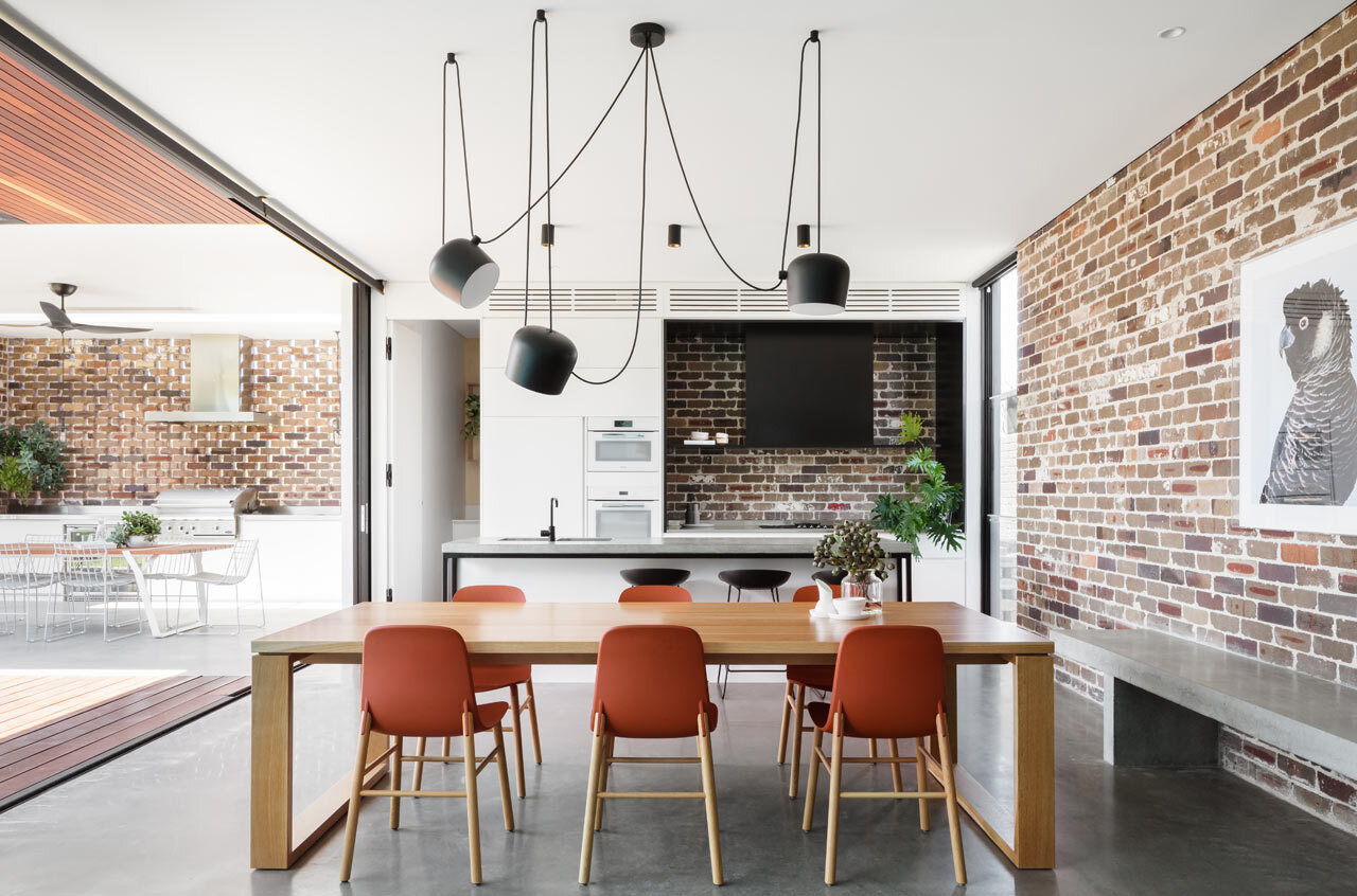 A recycled brick feature wall adds texture and warmth to the open plan living, dining and kitchen area.