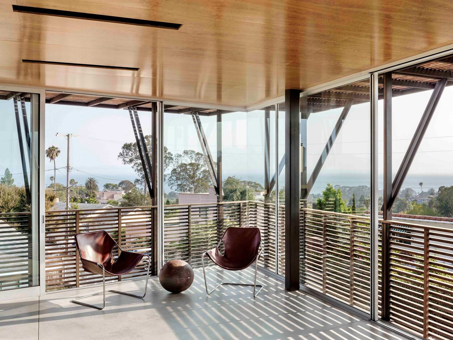 La sala de estar y la cocina están ubicadas en el último piso de esta casa moderna y ofrecen vistas panorámicas del Océano Pacífico y una terraza al aire libre.