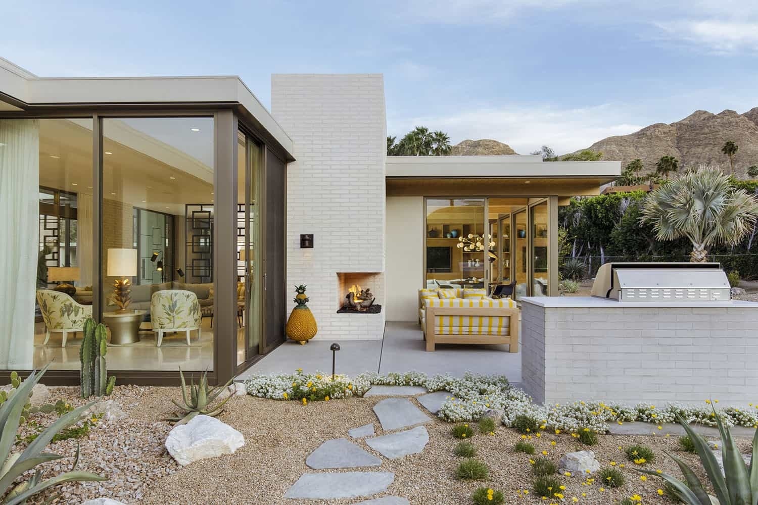 An outdoor fireplace and built in barbecue integrated into a mid century home’s architecture.